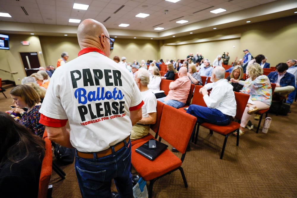 A paper ballot supporter attends a State Election Board meeting at the Dawson County Government Center in April. (Miguel Martinez/AJC)