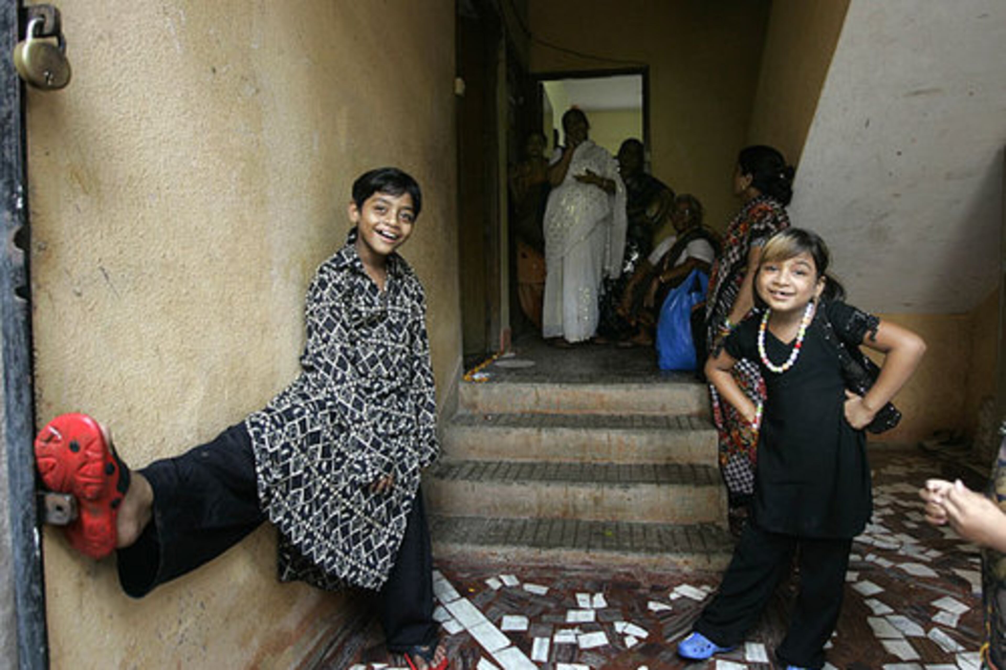 Azharuddin Mohammed Ismail, left, looks on outside his new home. British Director Danny Boyle decided to use inexperienced child actors who actually lived in Indian slums to portray the childhood of the principal characters in the film.