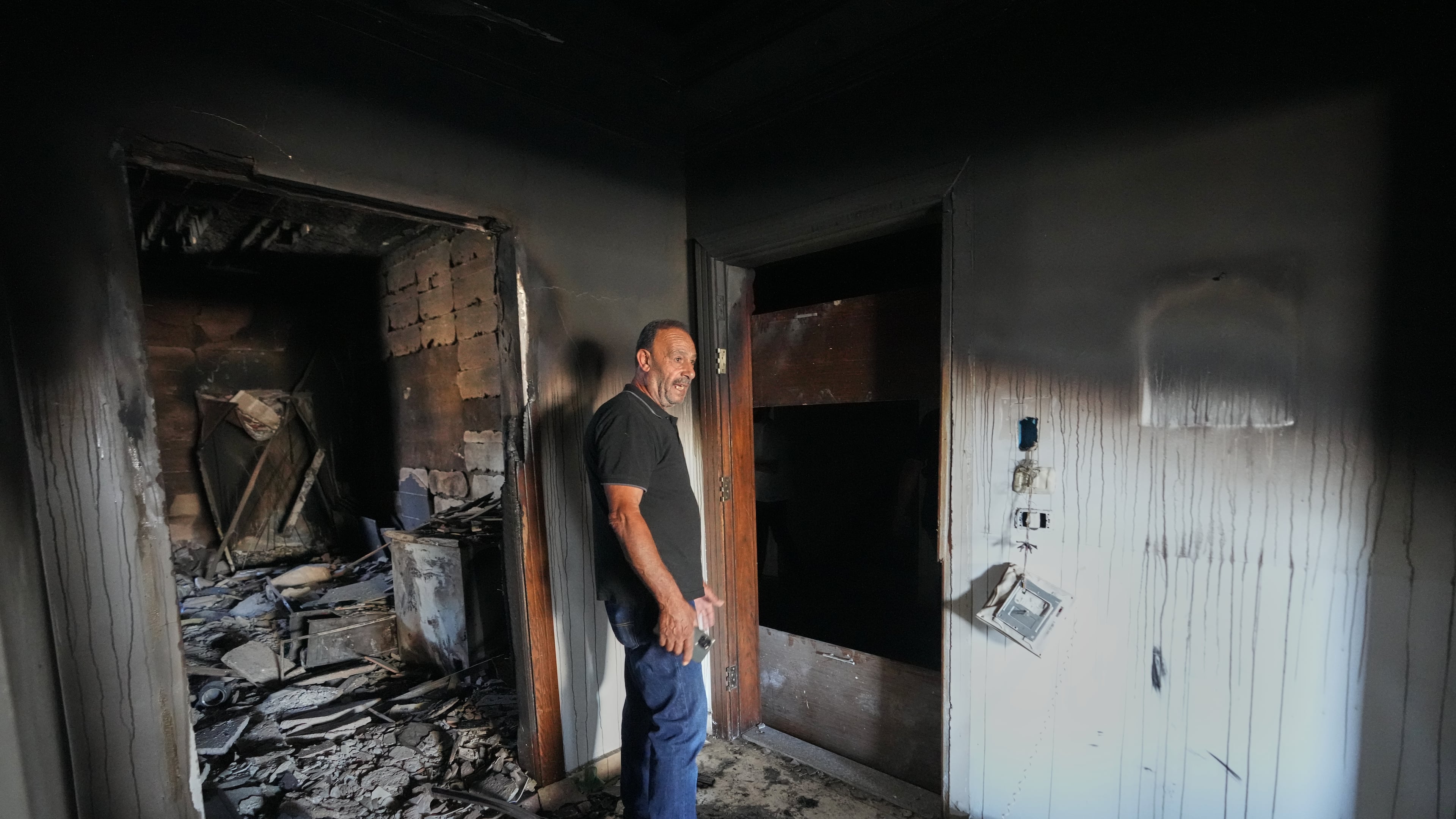 Resident Samih Haidar reacts as he inspects his burned apartment damaged in Israeli strikes in the southern port city of Tyre, Lebanon, Thursday, June 18, 2026. (AP Photo/Hassan Ammar)
