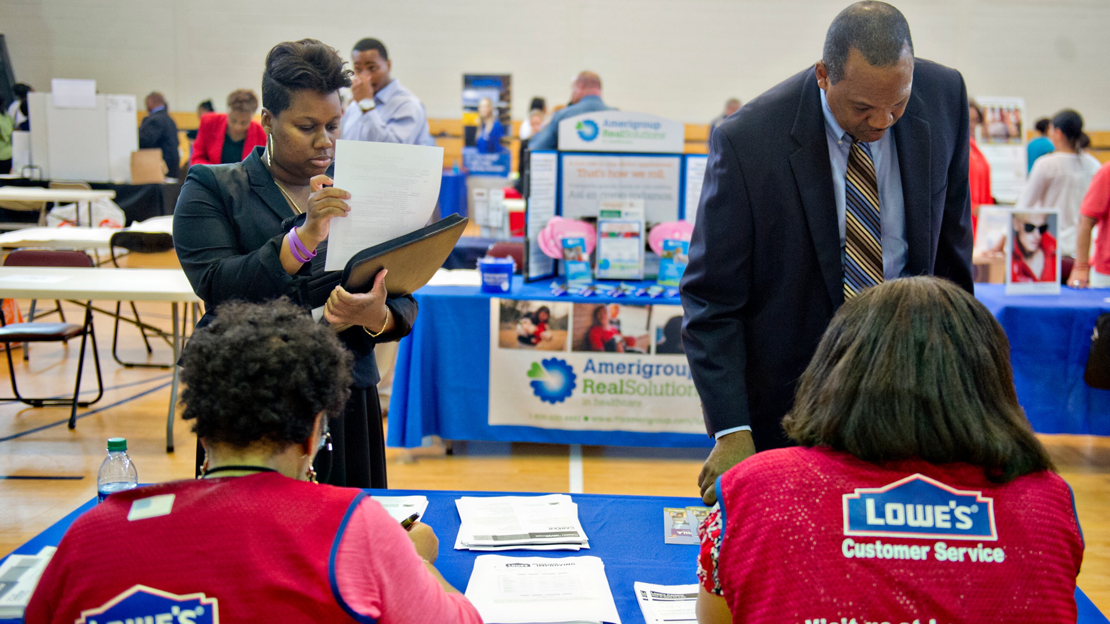 Krystal Flott (left) and Alan Harmon speak with Carolyn Beasley and Tracey Scott from Lowe's as they attend the South Clayton Job Fair at the South Clayton Recreation Center in Hampton on Sept. 30.