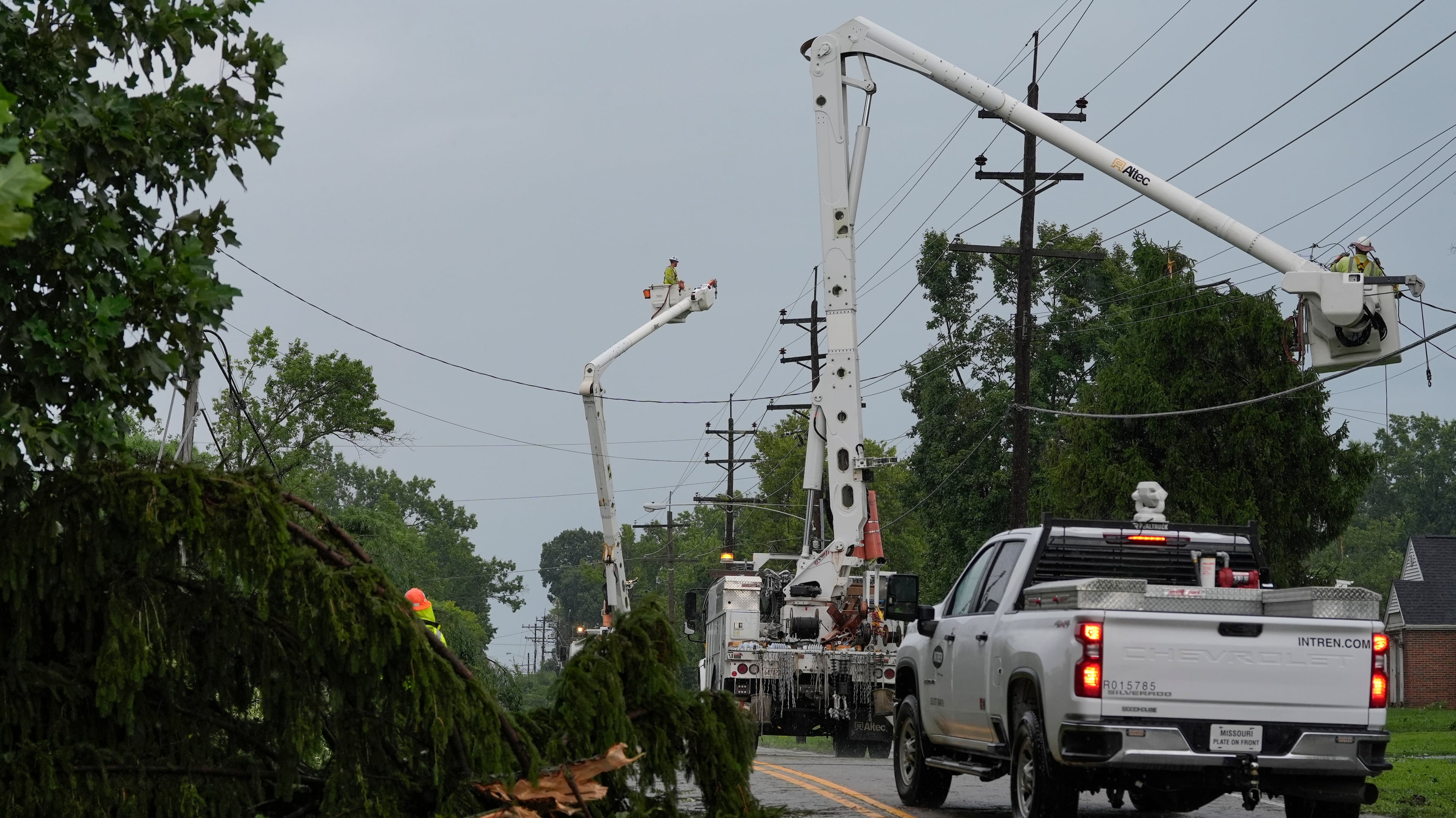 Crews work along Race Road among trees and power lines downed by severe storms on Tuesday, to restore power in Cincinnati on Wednesday, Aug. 12, 2026. (AP Photo/Carolyn Kaster)