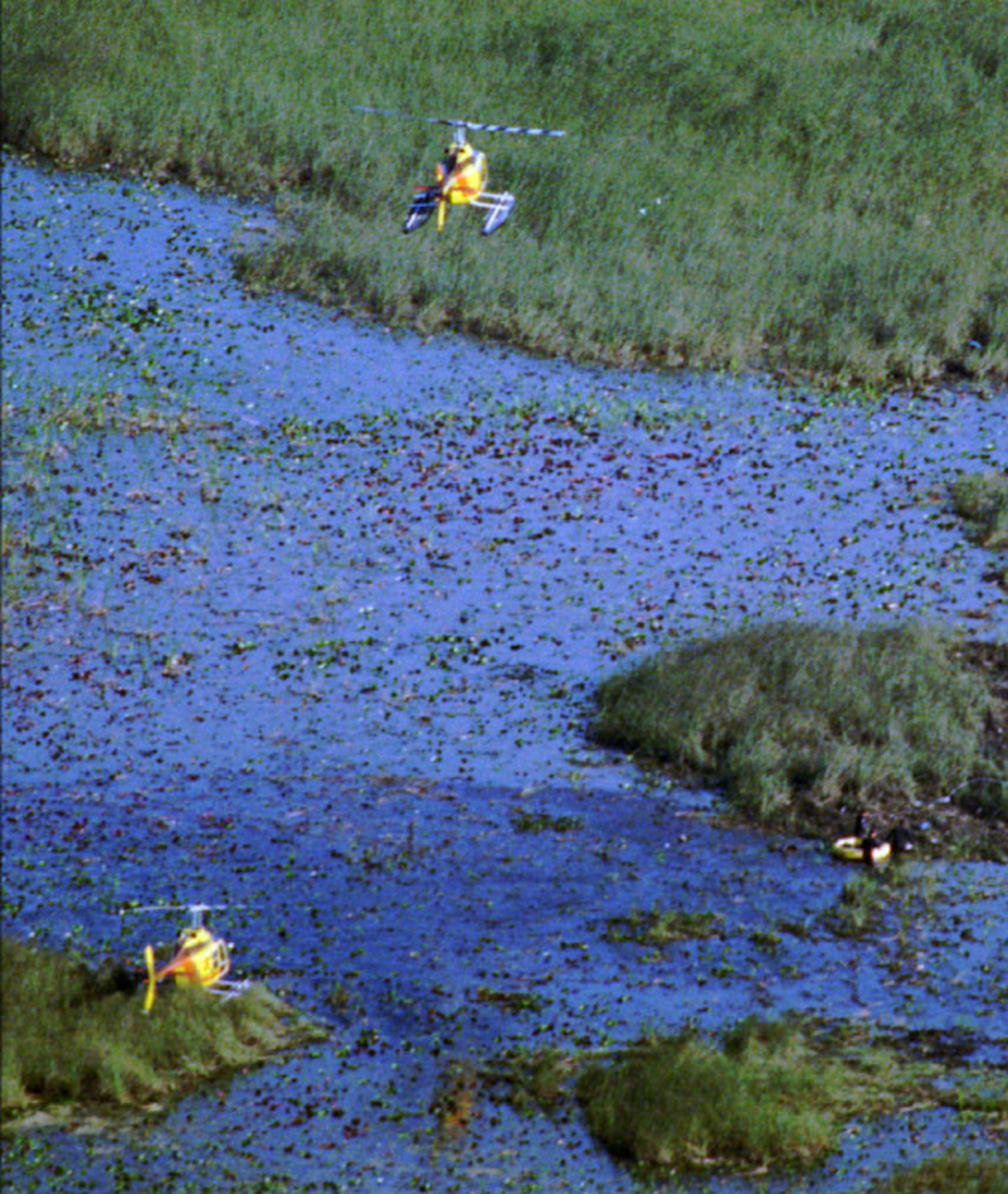 A helicopter lifts off the area where a ValuJet airliner crashed Saturday, May 11, 1996 in the Florida Everglades. Divers work in the water, looking for bodies and debris from the crash which carried 109 people to their deaths. (AP Photo/Phil Sandlin)