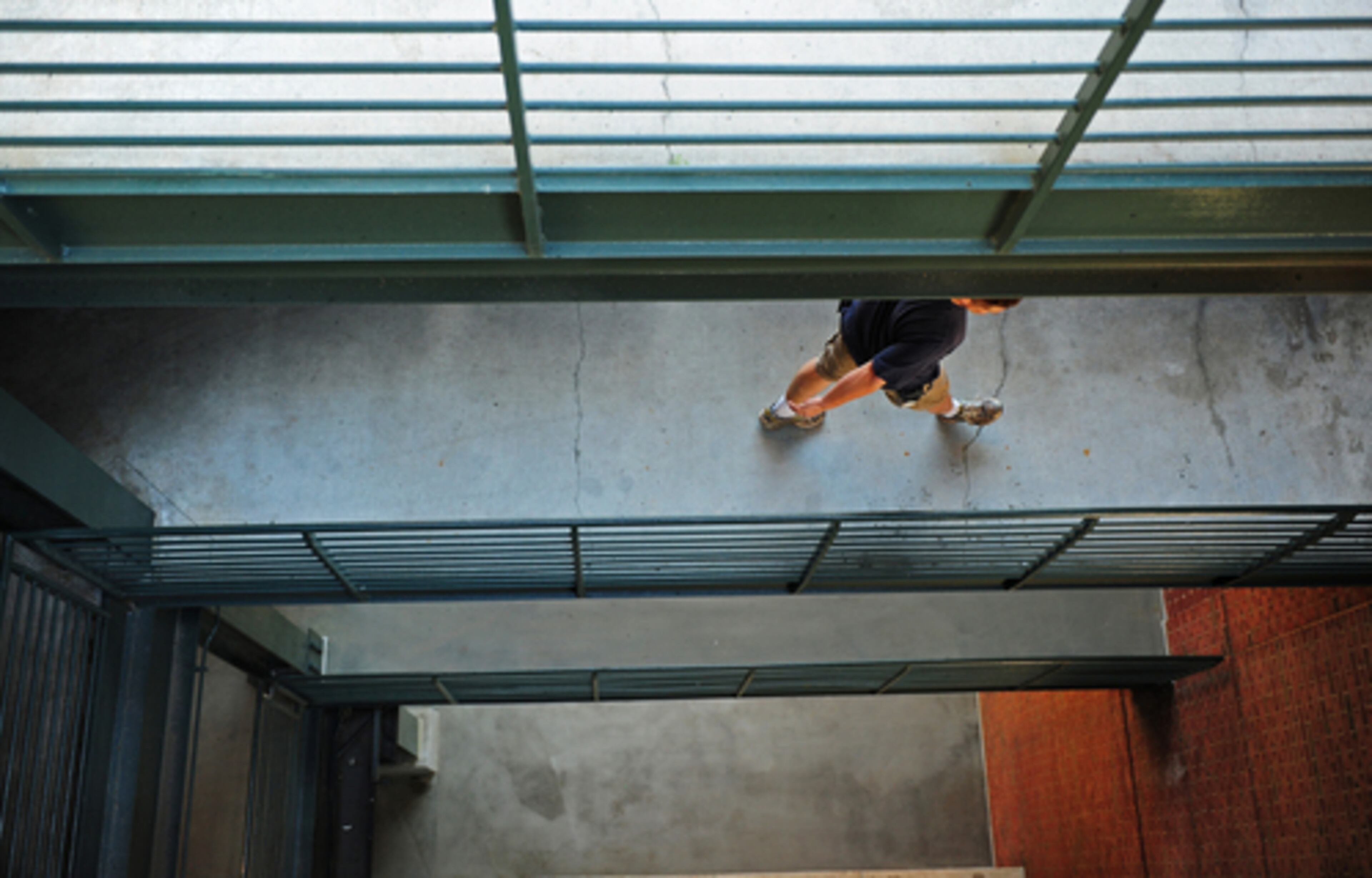 A man walks through the concourse level at Turner Field Thursday where 25-year-old Justin Hayes fell to his death at Wednesday night's Braves vs. Mets game. Hayes fell from where this photograph was taken to nearly the concrete level at the bottom of the photograph.