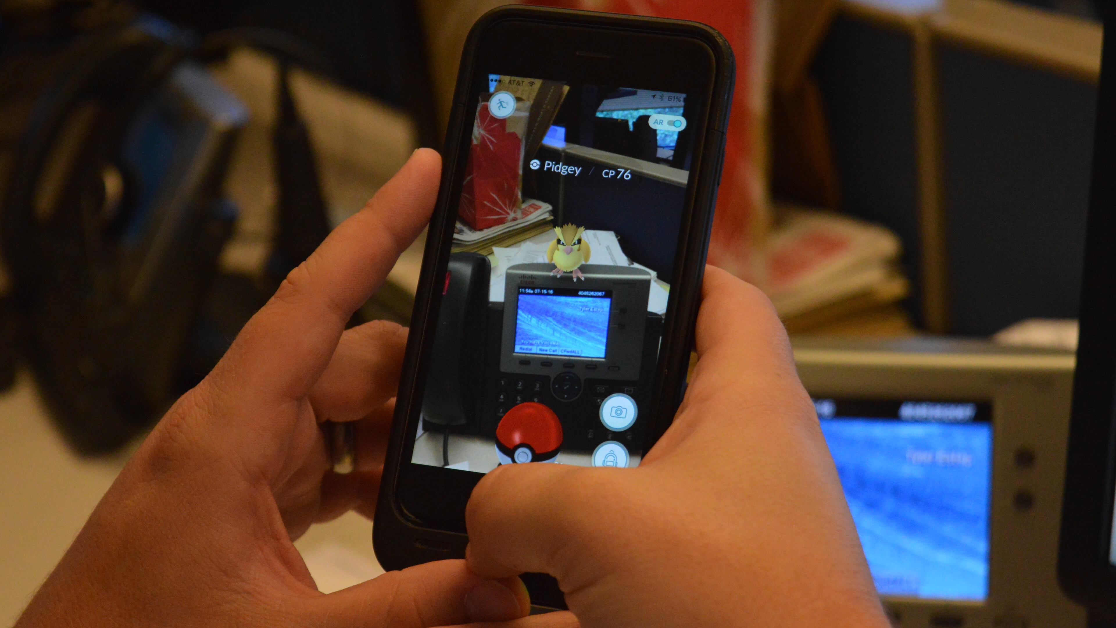 A Pokemon Go player finds a wild Pidgey on his desk.