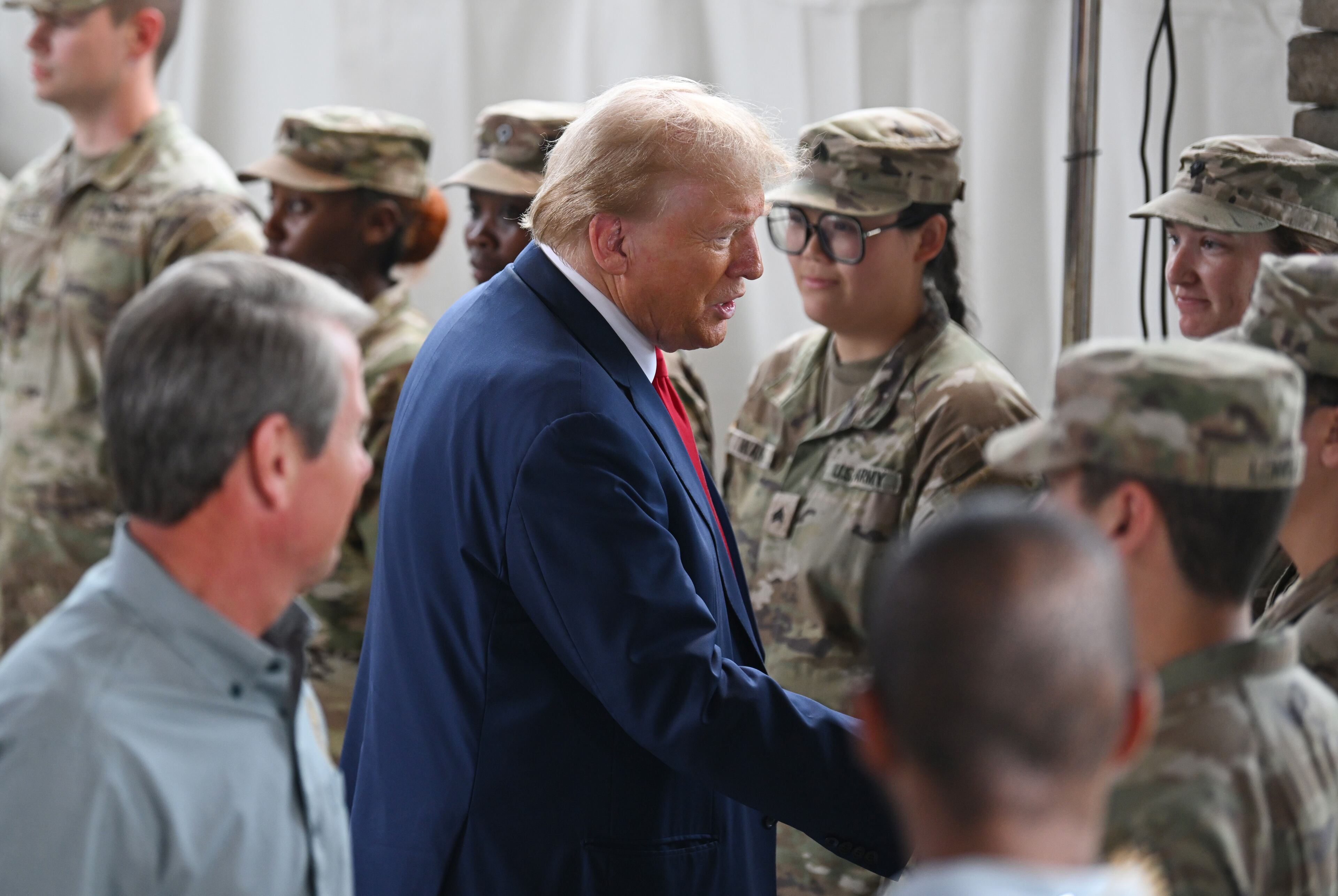 Former President Donald Trump and Gov. Brian Kemp shake hands with members of the Army National Guard as they arrive before delivering remarks to members of the press at Columbia Performing Arts Center, Friday, October 4, 2024, in Evans. Former President Donald Trump and Gov. Brian Kemp made their first appearance together since before the 2020 election, traveling to east Georgia to survey damage from Hurricane Helene. (Hyosub Shin / AJC)