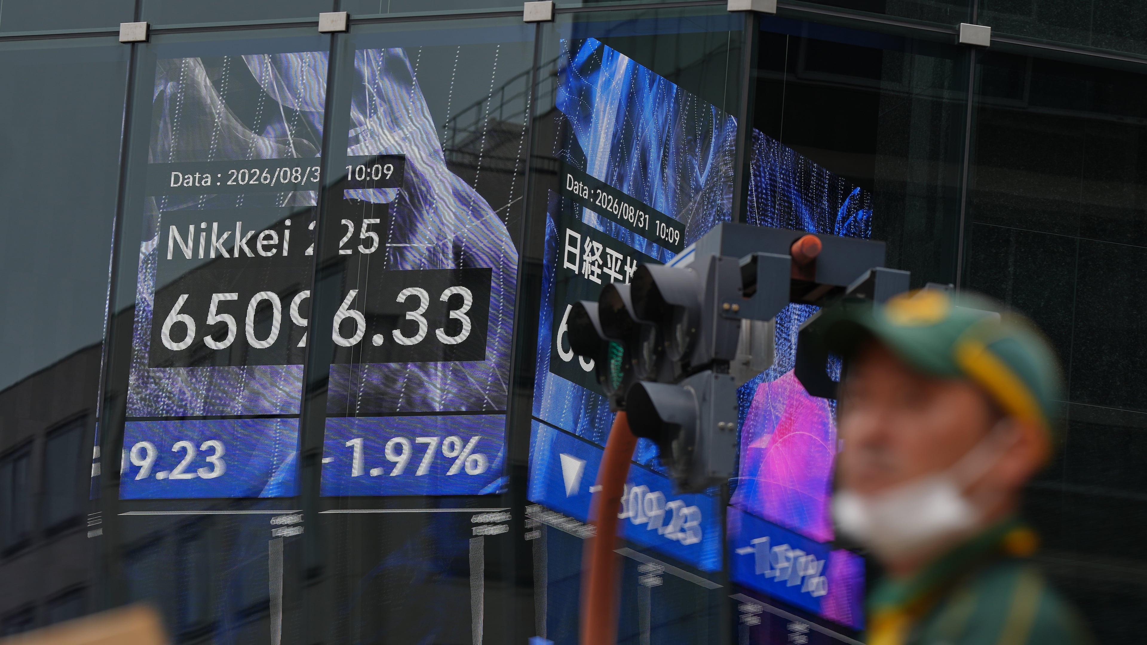 A person walks in front of an electronic stock board showing Japan's Nikkei index at a securities firm Monday, Aug. 31, 2026, in Tokyo. (AP Photo/Eugene Hoshiko)