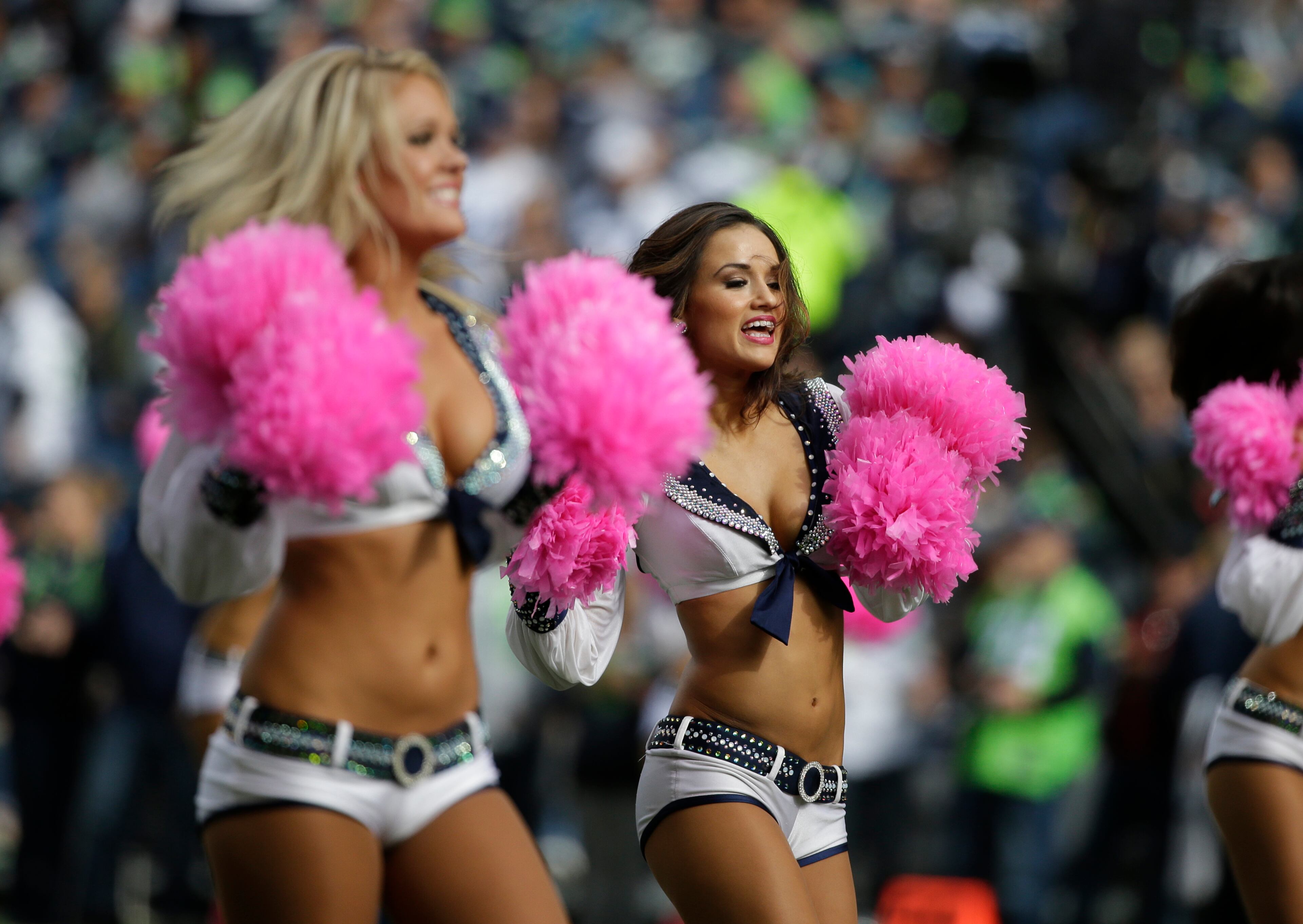 Seattle Seahawks Sea Gals cheerleaders perform with pink pom-pons in support of Breast Cancer Awareness in the first half of an NFL football game against the Dallas Cowboys, Sunday, Oct. 12, 2014, in Seattle. (AP Photo/Elaine Thompson)