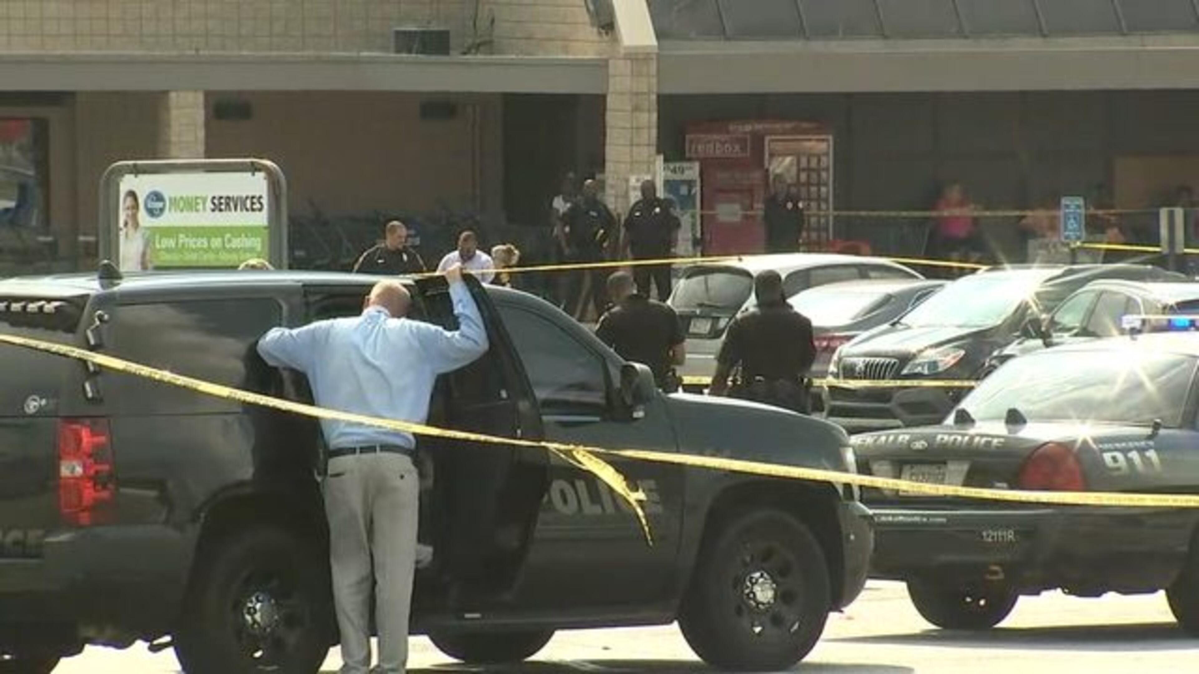 Three men suspected of attempting to rob a couple were shot by the male victim outside a DeKalb County shopping center, police said. (Credit: Channel 2 Action News)