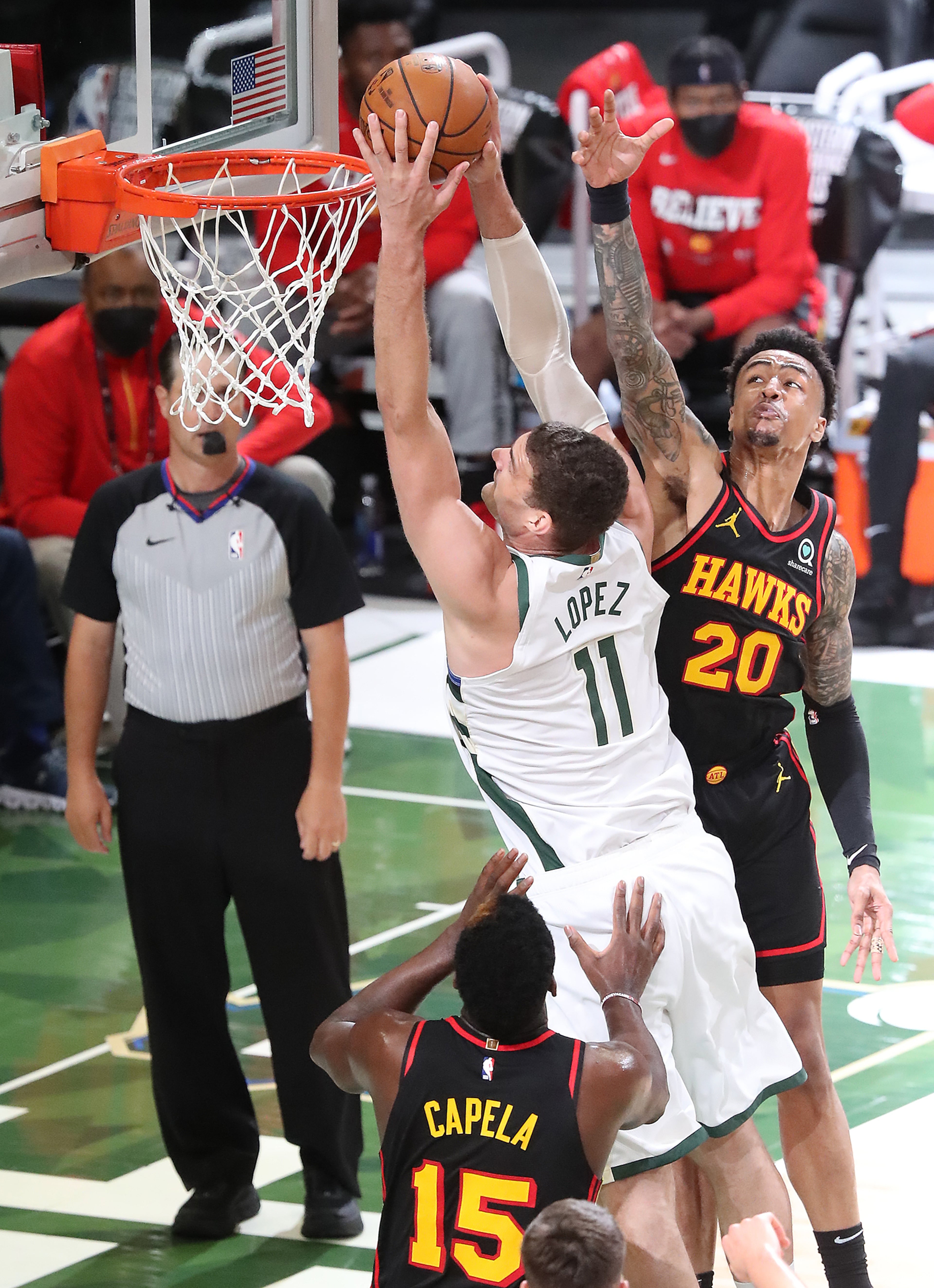 Milwaukee Bucks center Brook Lopez goes to the basket for two of his 33 points past Atlanta Hawks defenders Clint Capela (left) and John Collins. “Curtis Compton / Curtis.Compton@ajc.com”
