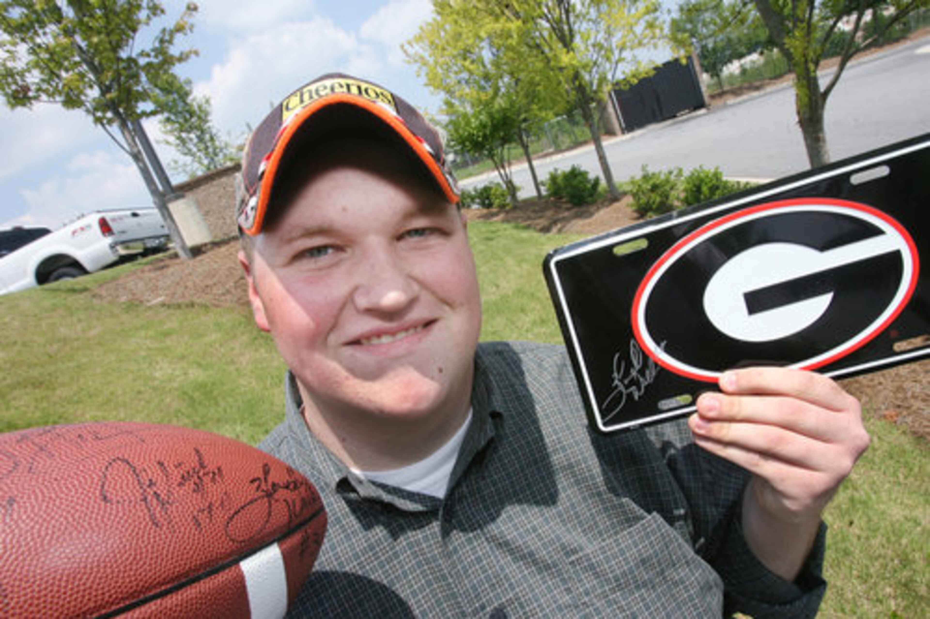 NASCAR and UGA football fan Christopher Fouche, of Nicholson, proudly shows his newly-autographed license tag and football courtesy of the UGA football great.