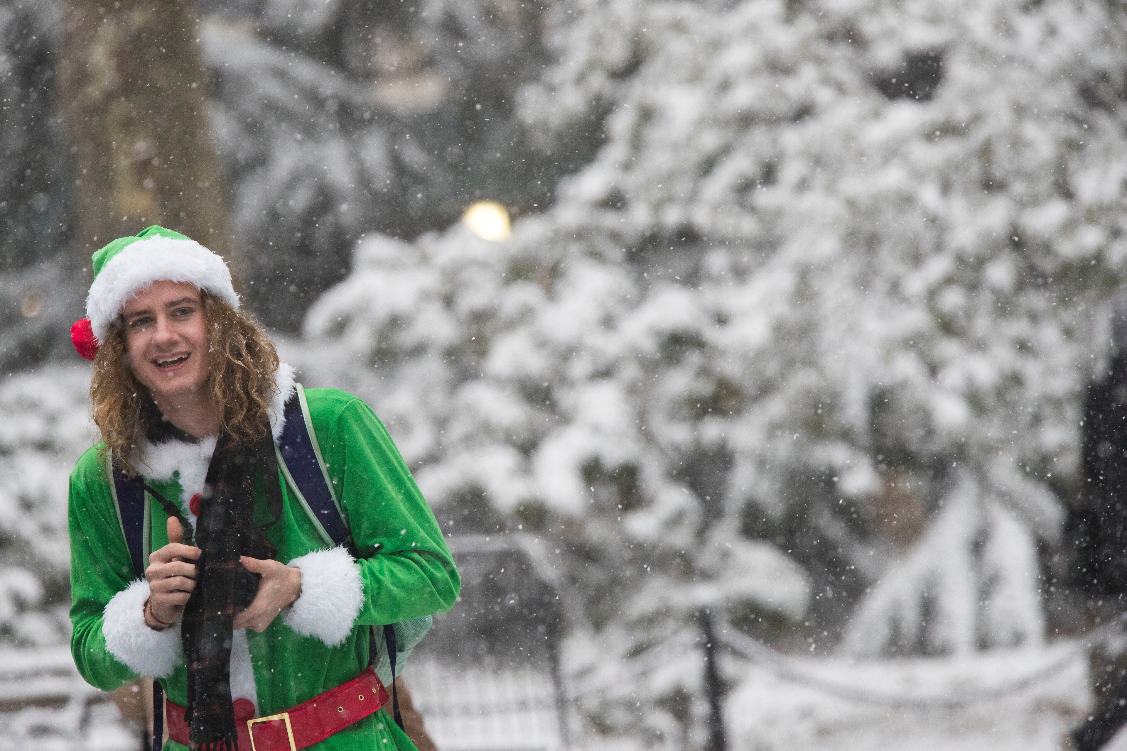 Snow falls on a Santa Con participant as he walks through City Hall park, Saturday, Dec. 9, 2017, in New York. (AP Photo/Mary Altaffer)