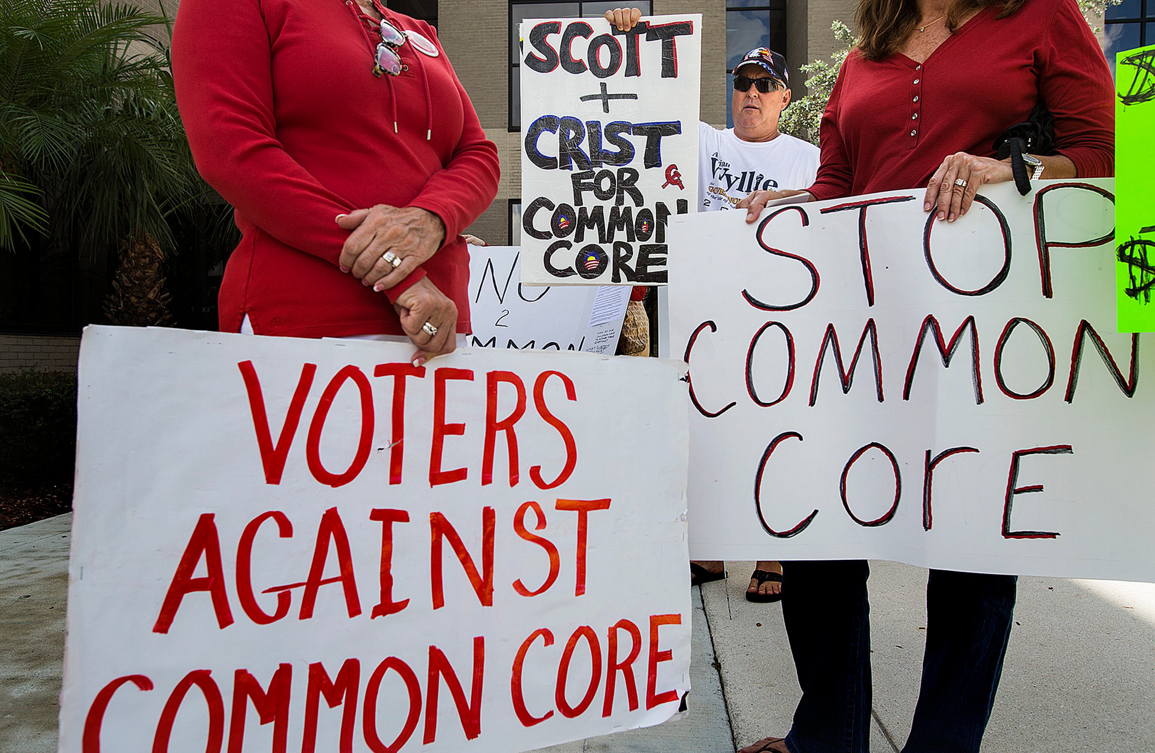 Dan Ray, holds up a sign with other opponents of Common Core outside the Palm Beach County School Board offices before a meeting in this 2014 file photo, in West Palm Beach.