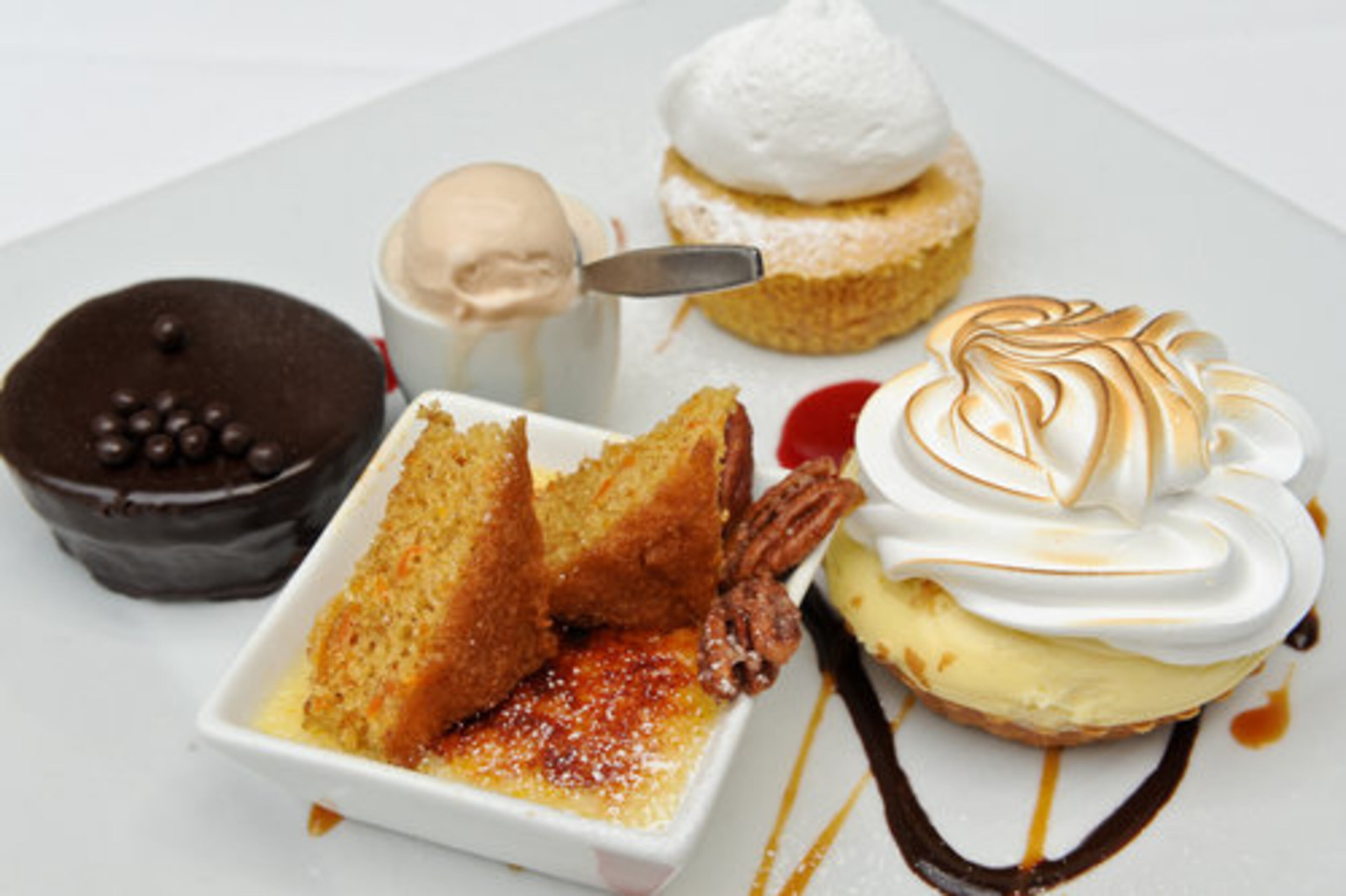 Banana peanut butter cream pie (center), cream cheese creme brulee, carrot cake and candied pecans. dark chocolate cupcake with ganache glaze and crunchy chocolate pearls and pumpkin souffle cheese cake with marshmallow creme at Rathbun's in Atlanta. John Kessler calls it "a special place that still defines one kind of greatness in Atlanta." Four stars.