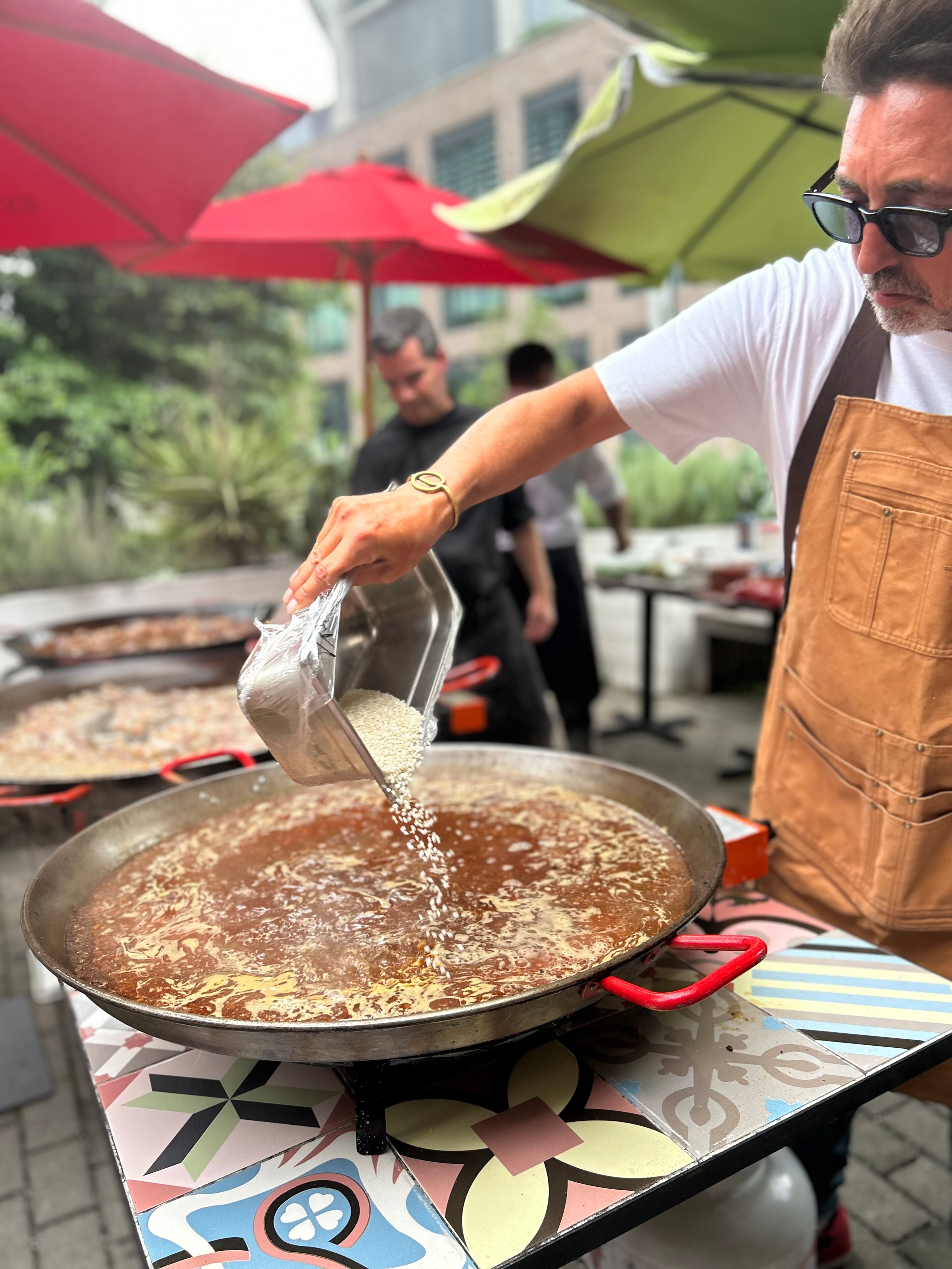 Chef and rice expert Edu Torres pouring rice during a paella demonstration at Buena Vida Tapas Bar. (Candy Hom for the AJC)