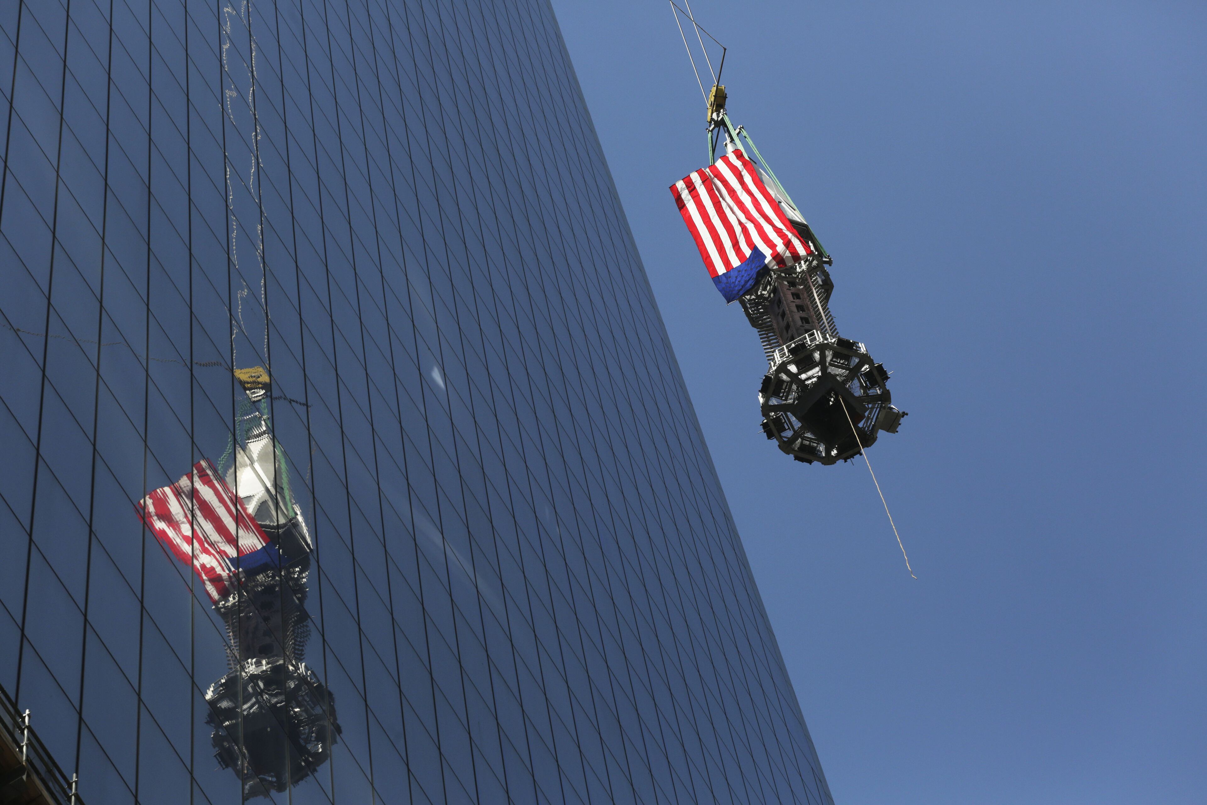 The final piece of the spire is hoisted to the roof of One World Trade Center in New York, Thursday, May 2, 2013. The piece will be attached to the spire at a later date, capping off the tower at 1,776 feet. (AP Photo/Mark Lennihan)