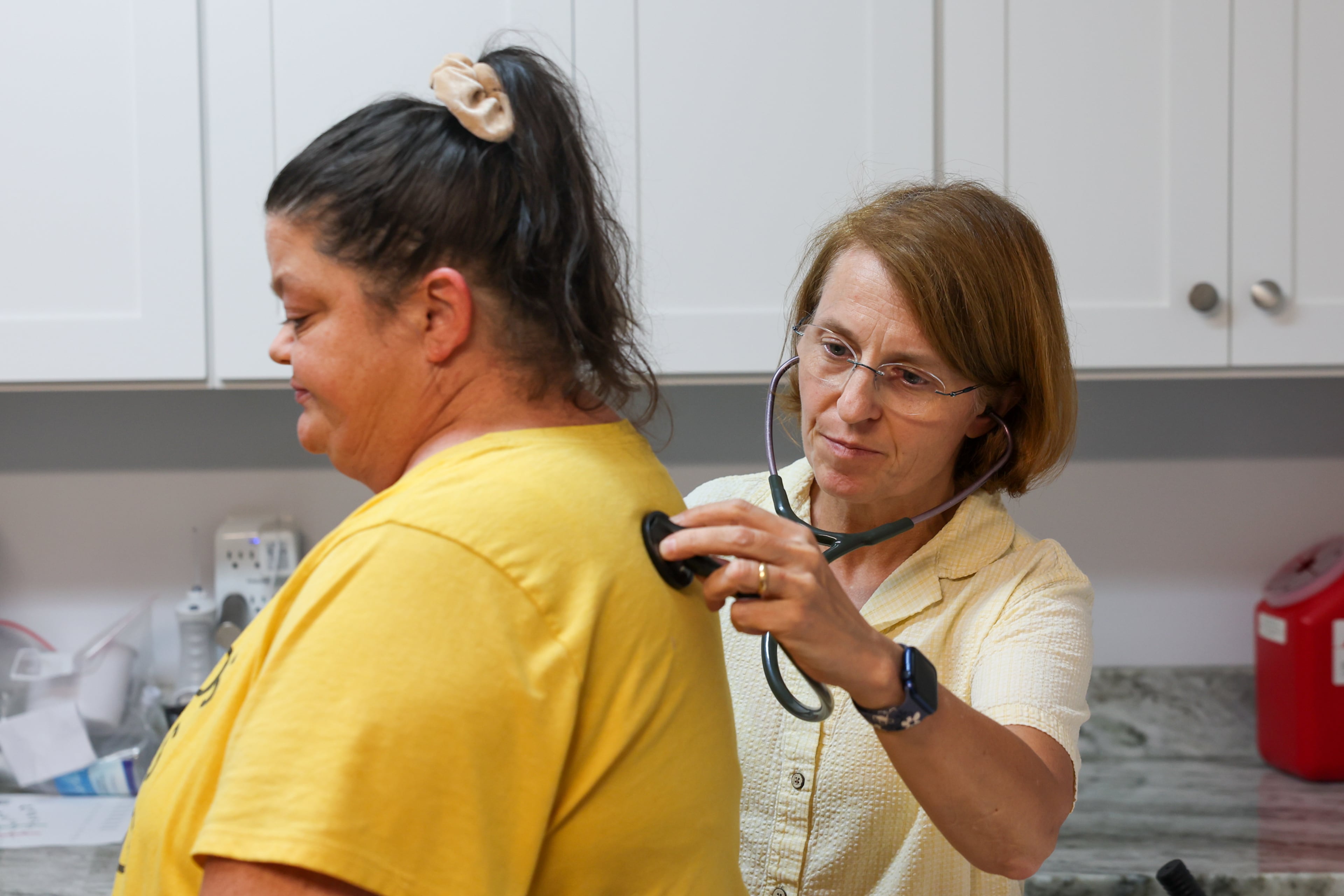Patient Angela Tyler (left) is seen by volunteer doctor Lenka Novotna at Open Arms Clinic, a free clinic in Toccoa, last month. (Arvin Temkar/AJC)