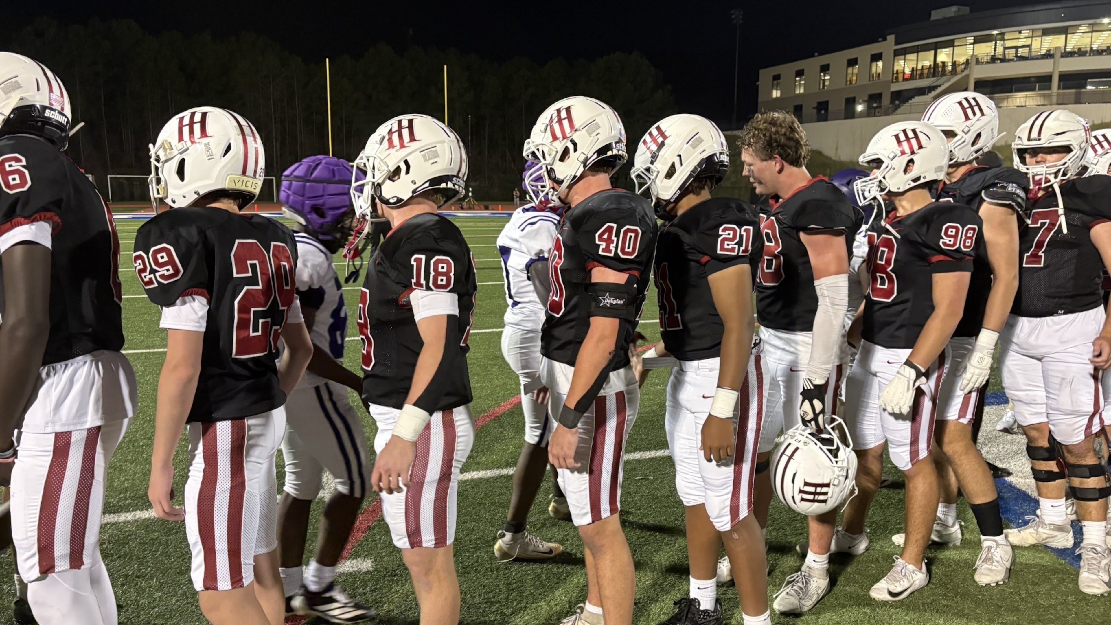 Players from Holy Innocents' and KIPP Atlanta Collegiate shake hands at midfield after Holy Innocents' 13-12 victory in a Region 5-3A game on Oct. 23, 2026, at Riverwood High School.