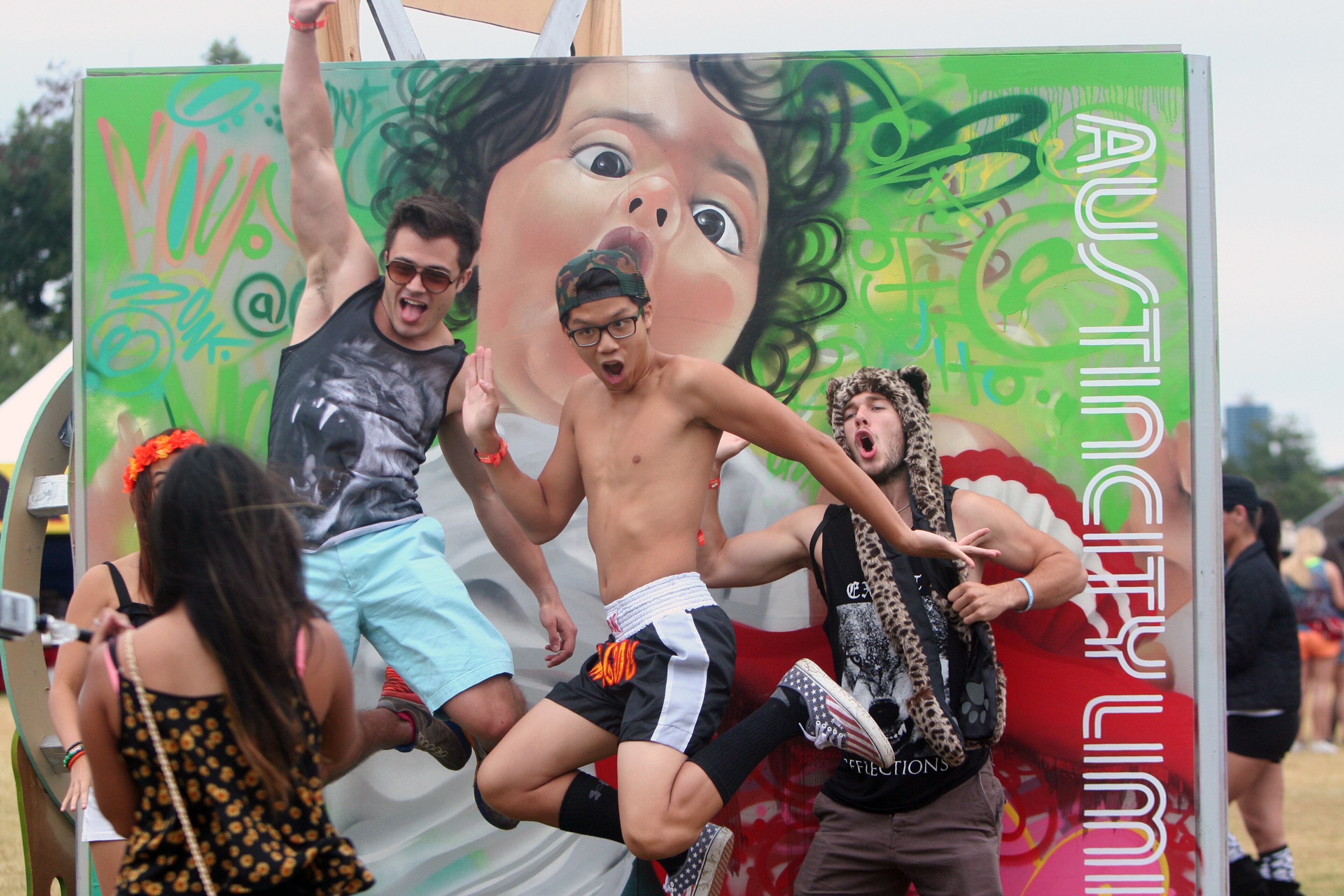 Gustavo Raskosky, Daniel Le and Austin Wadkins jump in front of a sign at Austin City Limits Music Festival, 10.11.14 MARCIAL GUAJARDO/ROUND ROCK LEADER
