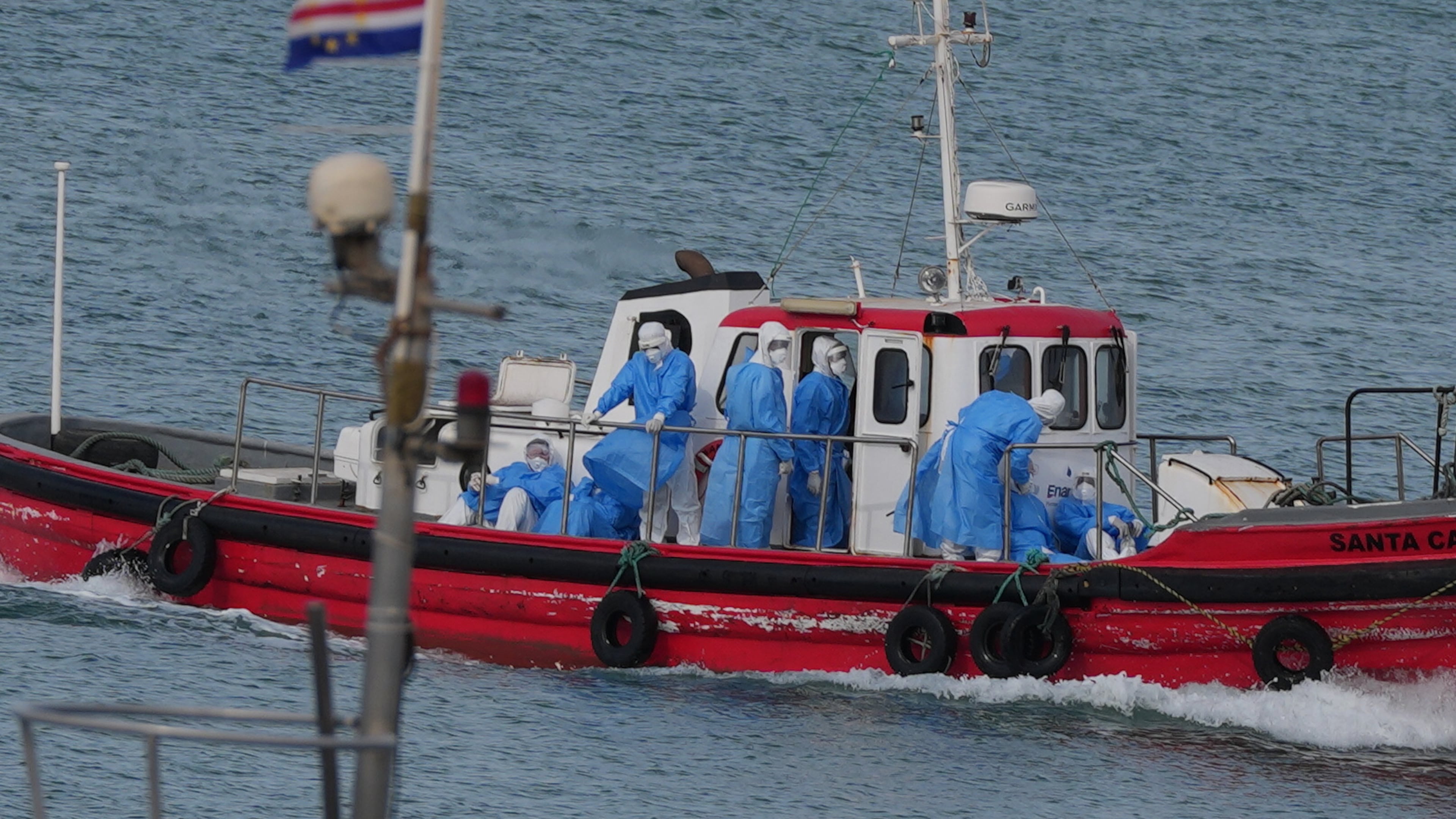 Health workers in protective gear arrive to evacuate patients from the MV Hondius cruise ship at a port in Praia, Cape Verde, Wednesday, May 6, 2026. (AP Photo/Misper Apawu)