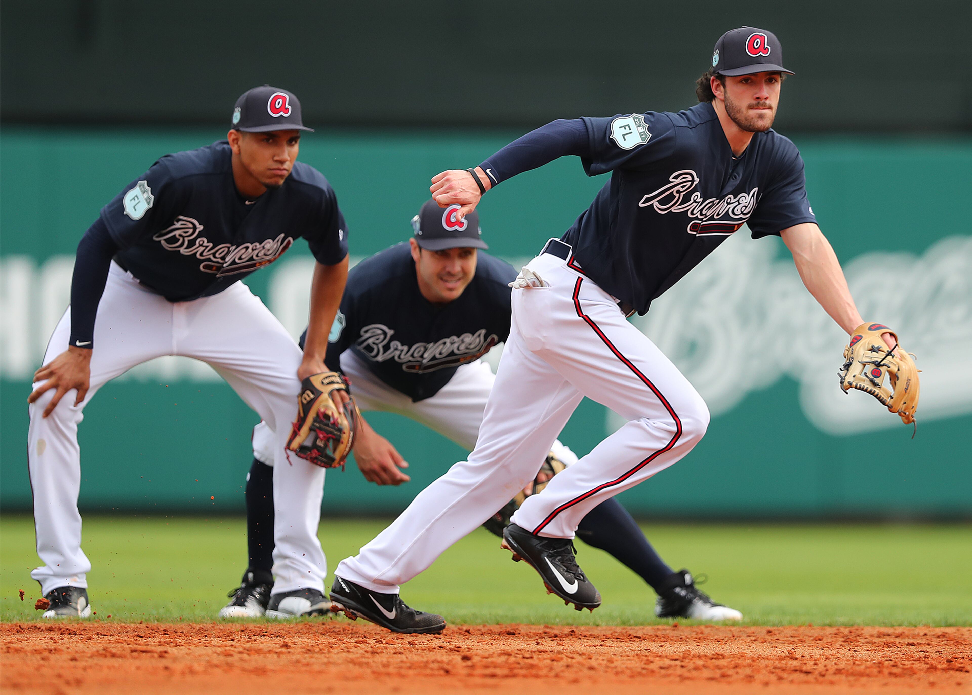 February 18, 2017, Lake Buena Vista, FL: Atlanta Braves infielders Johan Camargo (from left) and Chase DâArnaud look on while Dansby Swanson makes a play on a ground ball during the first full squad workout at Champion Stadium on Saturday Feb. 18, 2017, at the ESPN Wide World of Sports in Lake Buena Vista. Curtis Compton/ccompton@ajc.com