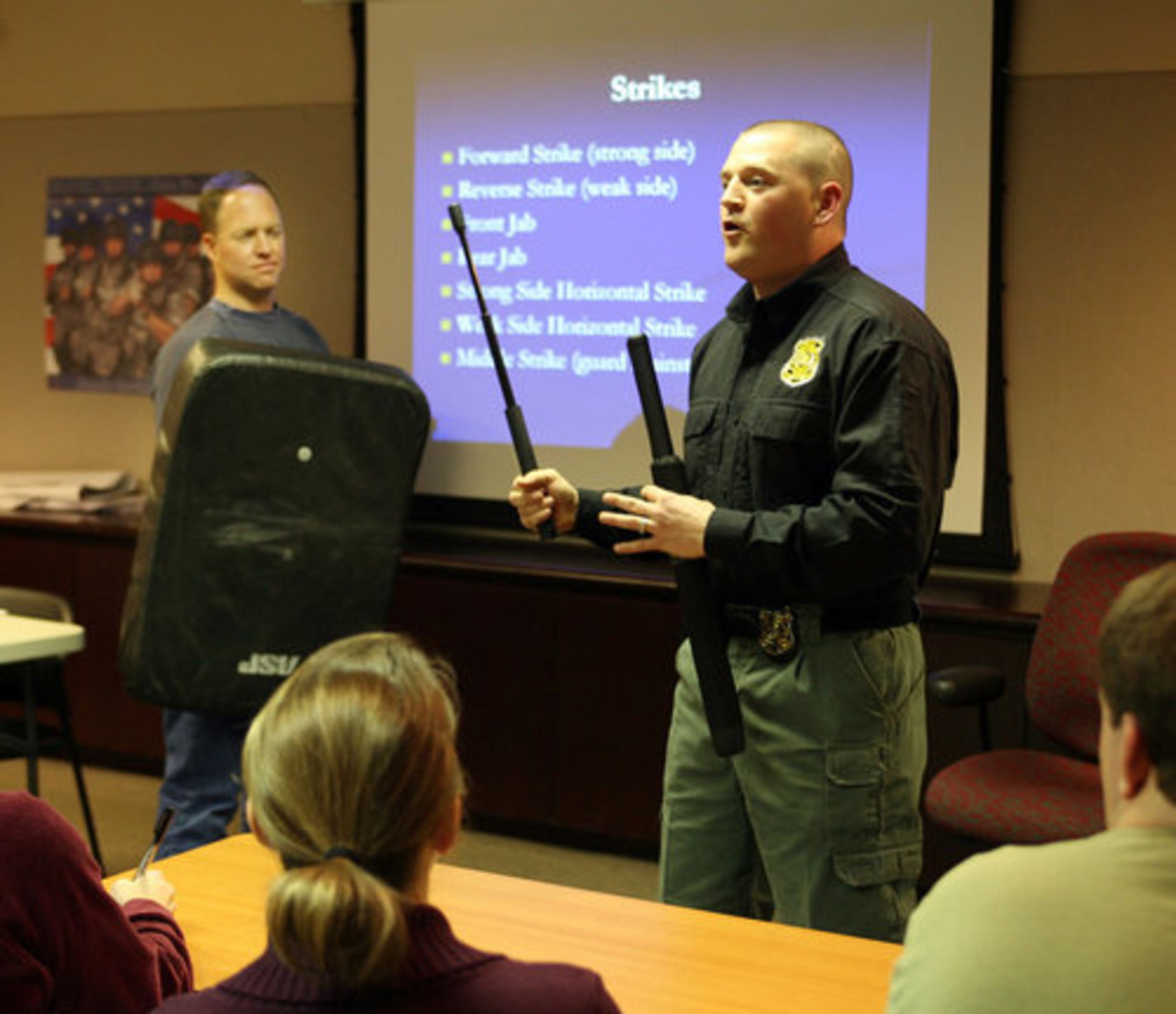 Sgt. Josh Emmett (right) talks about self defense techniques using a baton. About 20 officers and commanders led the weekly classes, while others took students on ride-alongs in patrol cars.