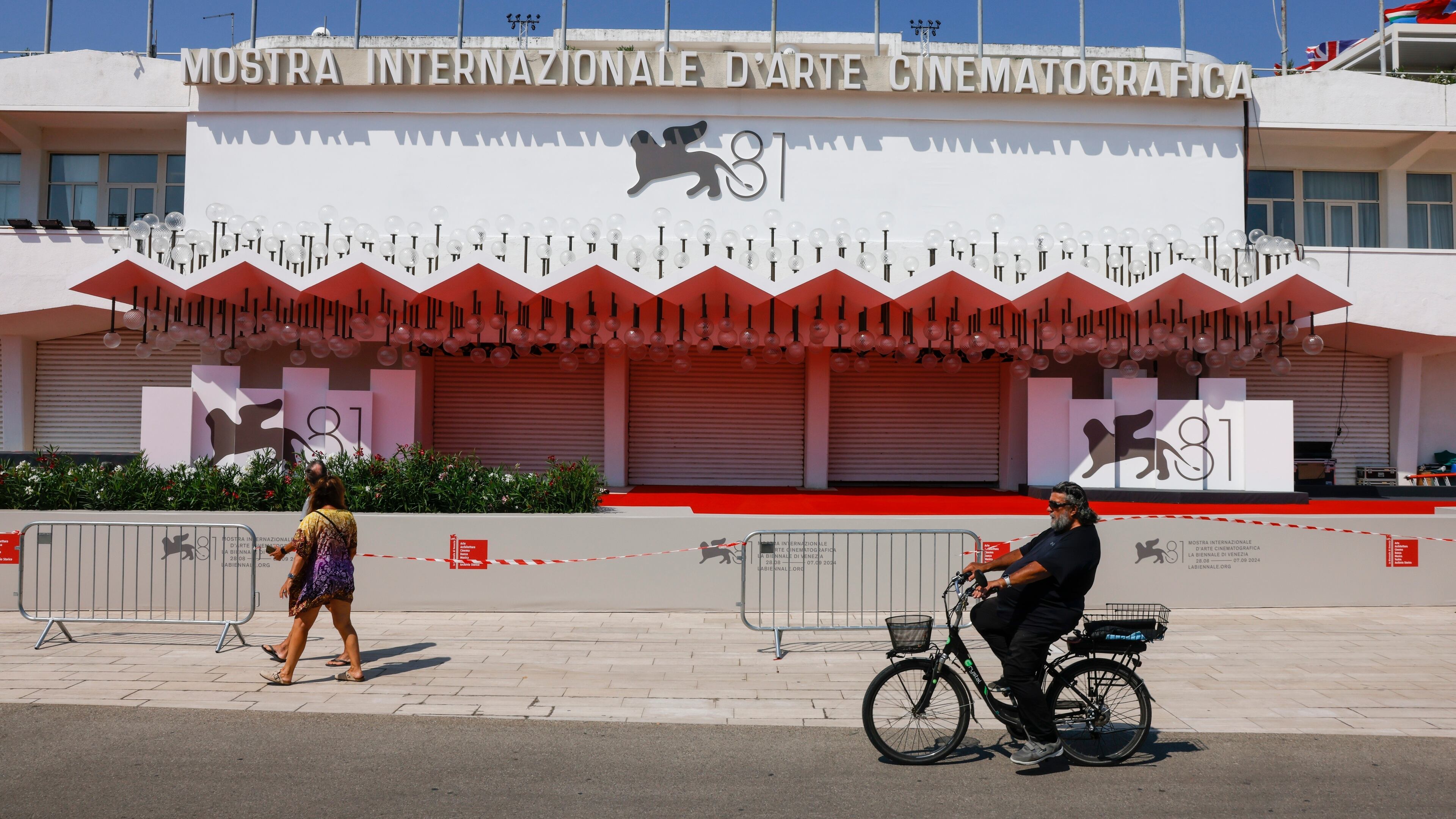 FILE - Festival goers pass the red carpet of the 81st edition of the Venice Film Festival in Venice, Italy, Aug. 27, 2024. (Photo by Vianney Le Caer/Invision/AP, File)