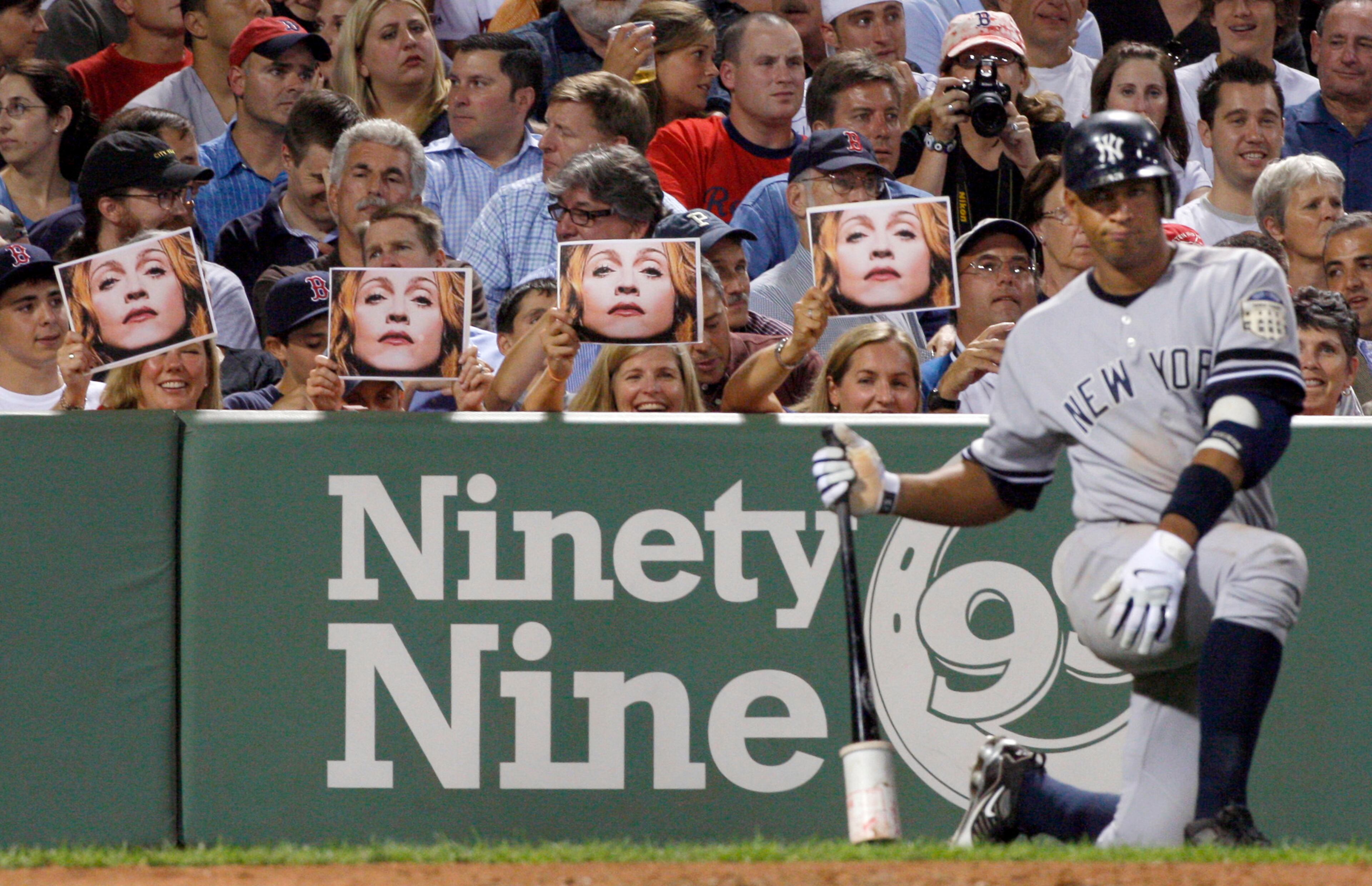 2008: Spectators hold up photos of Madonna as New York Yankees' Alex Rodriguez waits in the on-deck circle during the eighth inning of a baseball game against the Boston Red Sox at Fenway Park in Boston. Three MVP awards, 14 All-Star selections, two record-setting contracts and countless controversies later, A-Rod is the biggest and wealthiest target of an investigation into performance-enhancing drugs, with a decision from baseball Commissioner Bud Selig expected on Monday, Aug. 5, 2013. (AP Photo/Elise Amendola, File)