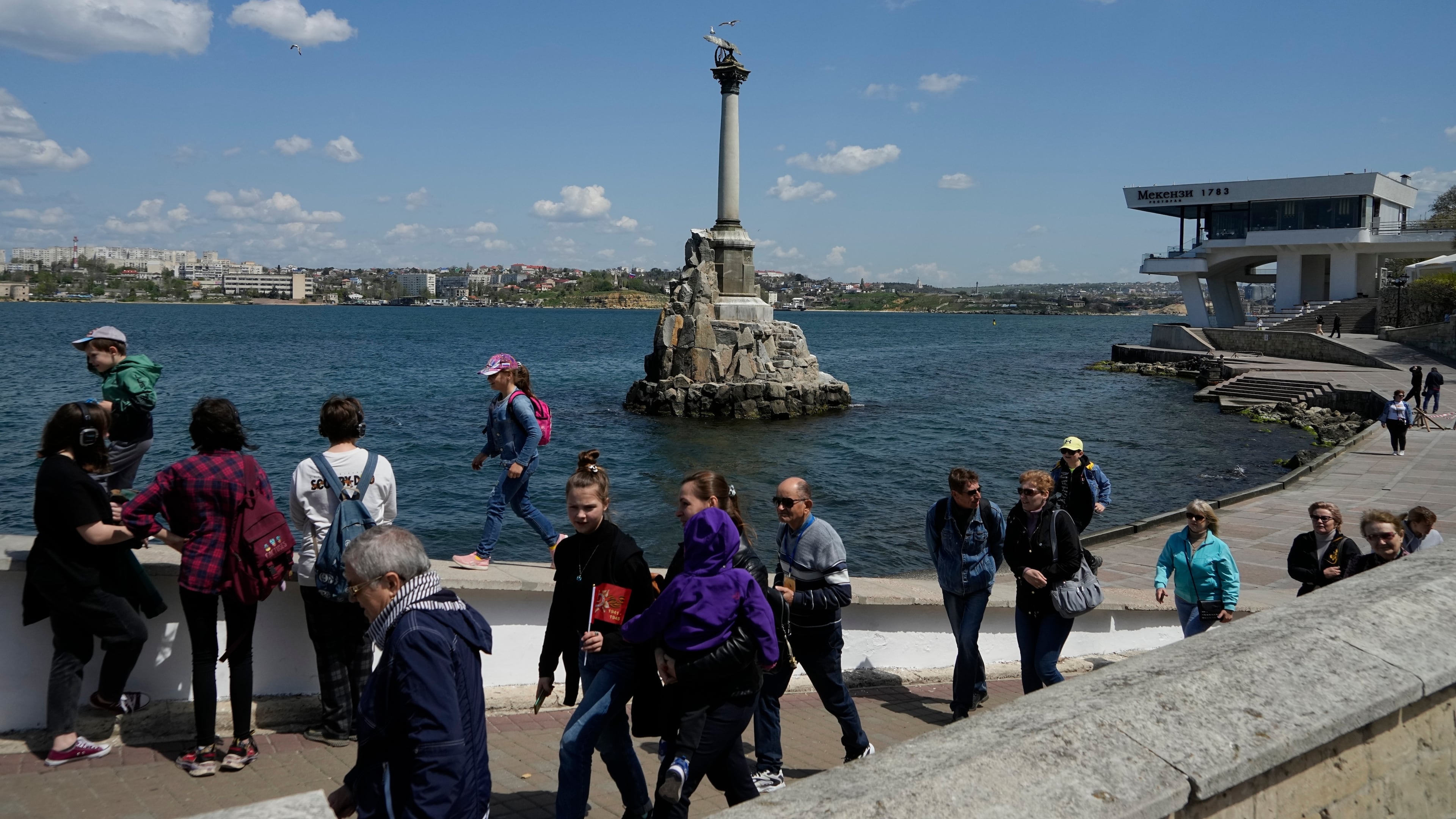 FILE - Tourists walk along an embankment in Sevastopol, Crimea, Monday, May 2, 2022. (AP Photo, File)