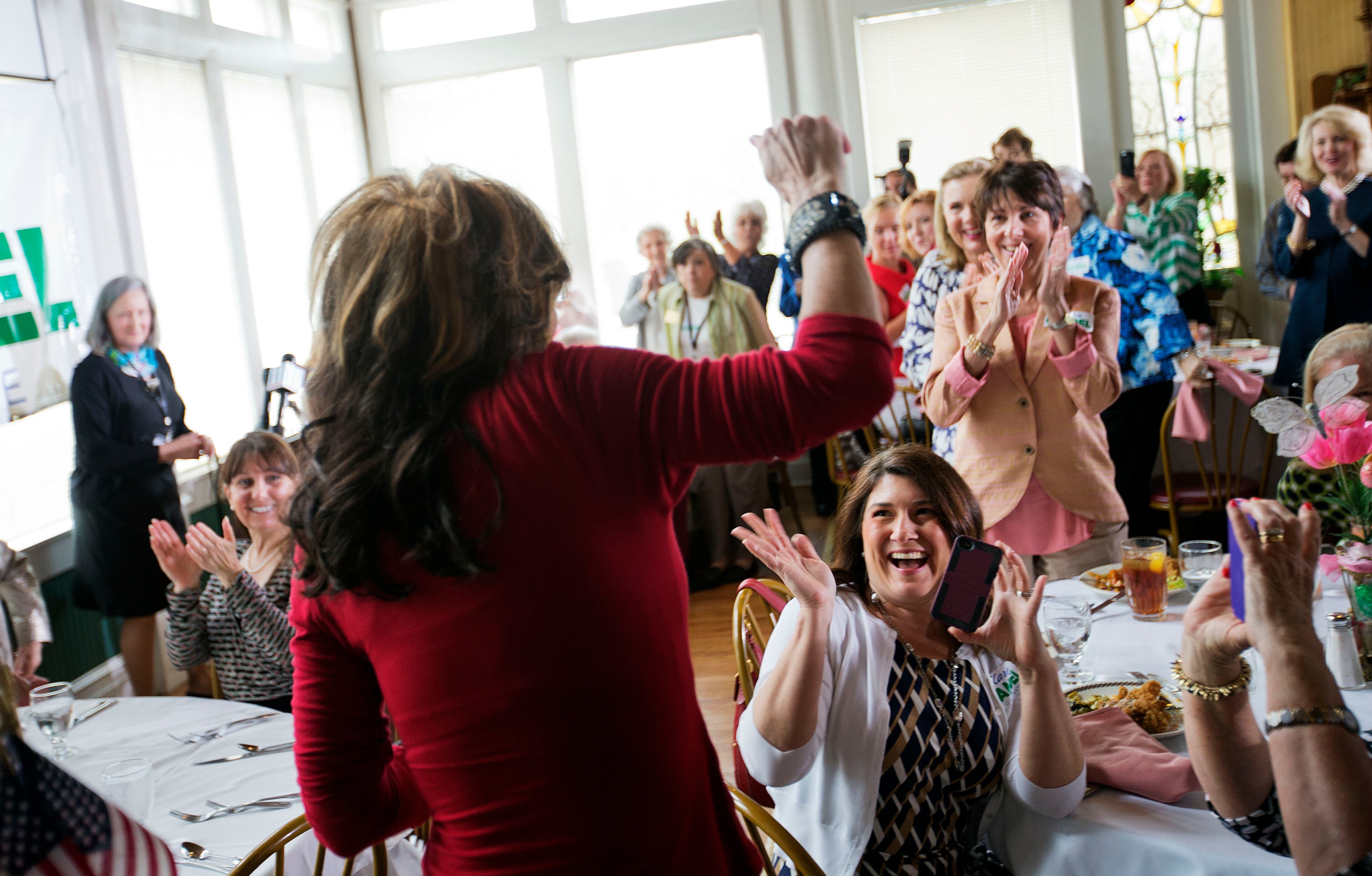 Charlene McGowan, of Roswell, Ga., right, cheers as former Alaska governor and 2008 Republican vice presidential nominee Sarah Palin, left, surprises a county women's group meeting to campaign for Republican candidate for U.S. Senate Karen Handel, Thursday, April 3, 2014, in Union City, Ga. Palin is riding to the defense of the only Republican woman in the nomination fight for Georgia's open Senate seat, hitting back against GOP rival David Perdue's apparent dismissal of Karen Handel's high school education. (AP Photo/David Goldman)