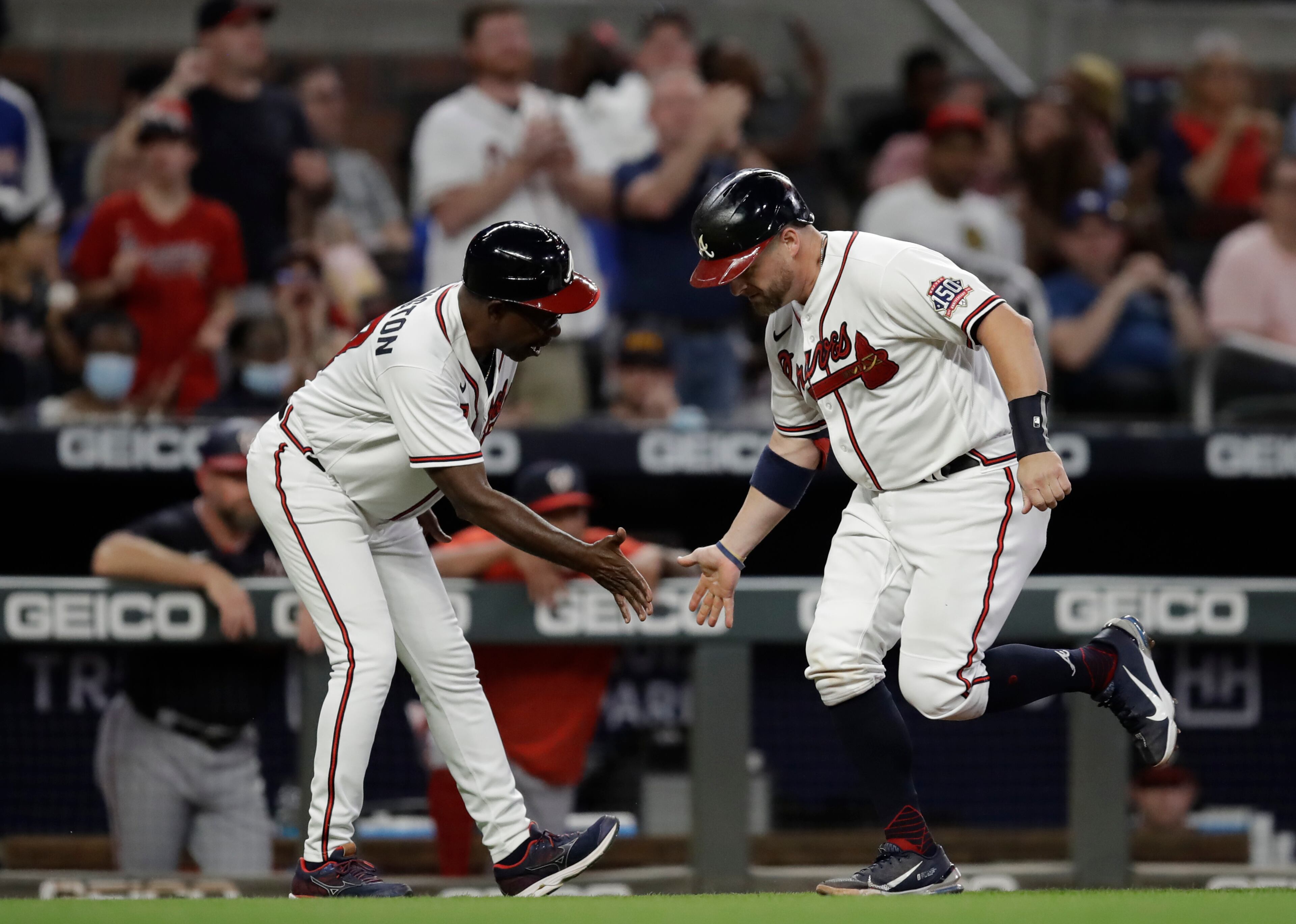 Atlanta Braves' Stephen Vogt, right, celebrates with third base coach Ron Washington after hitting a home run off Washington Nationals pitcher Erick Fedde in the third inning of a baseball game Thursday, Sept. 9, 2021, in Atlanta. (AP Photo/Ben Margot)