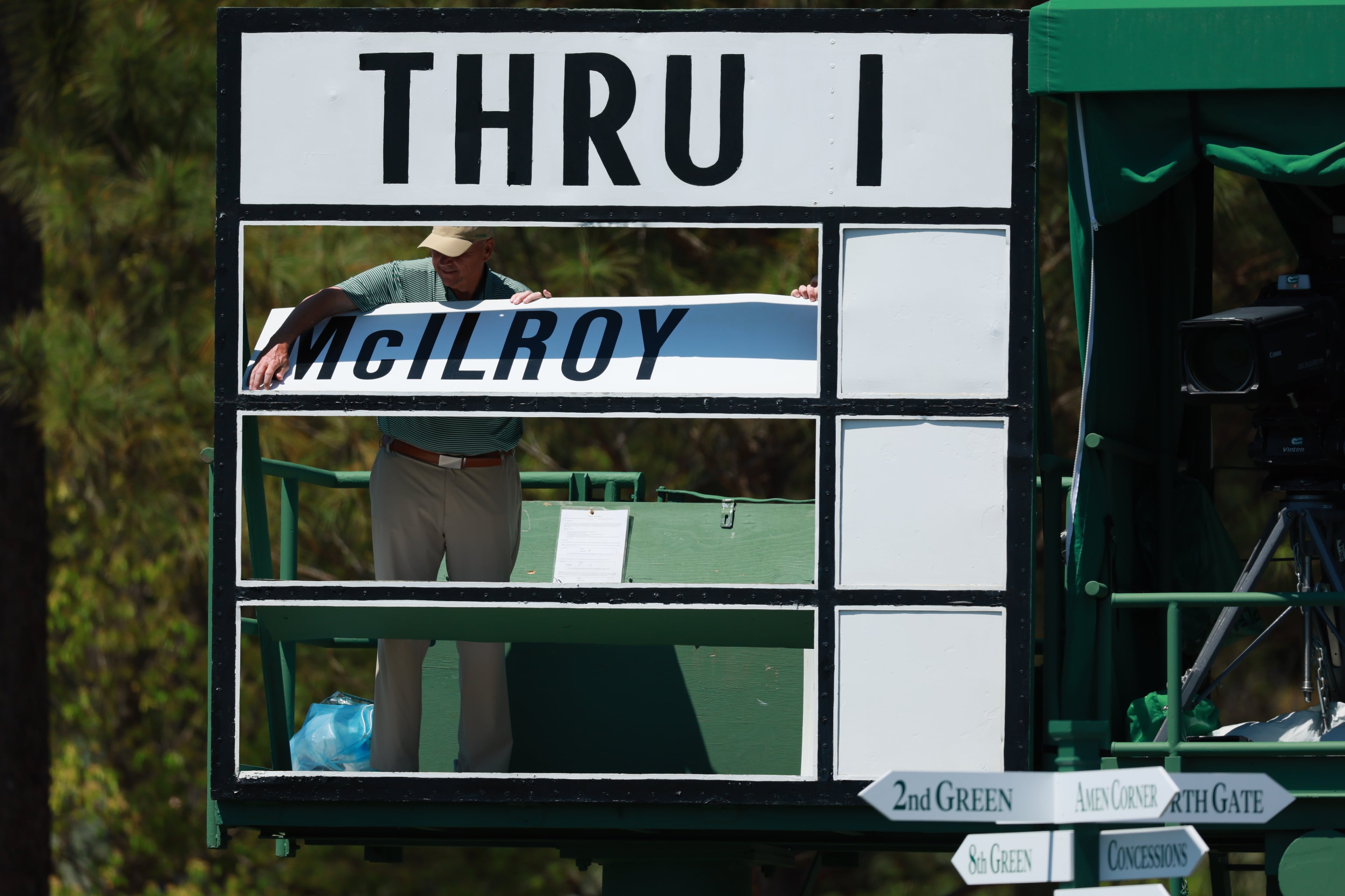 An Augusta Naitonal employee adjusts a leaderboard during the second round of the Masters on Friday. (Jason Getz/AJC)
