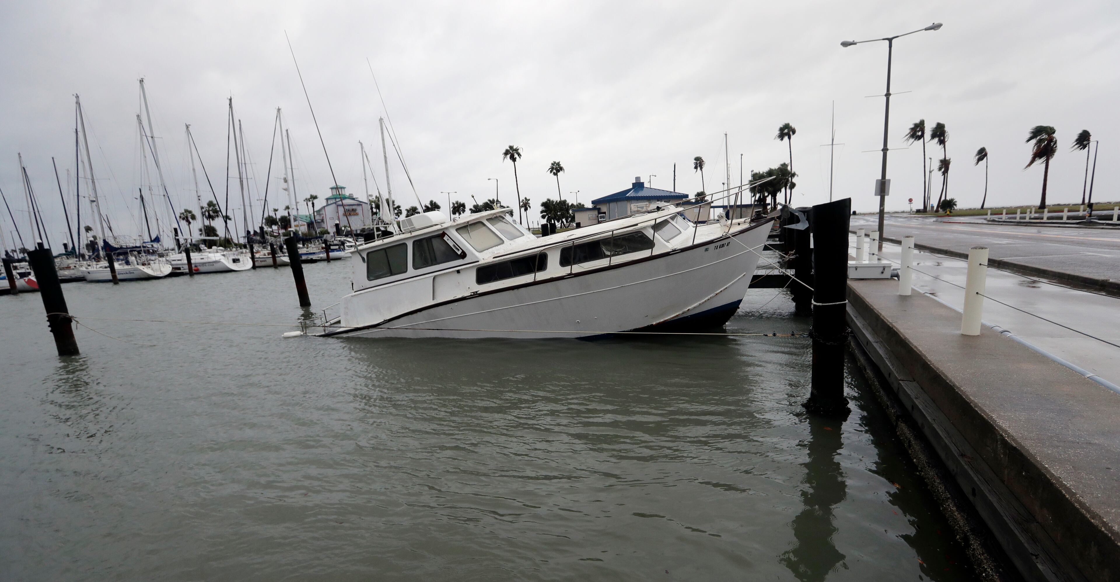 A fishing boat is left partial submerged after Hurricane Harvey swept through the area, Saturday, Aug. 26, 2017, in Corpus Christi, Texas. Harvey has been further downgraded to a Category 1 hurricane as it churns slowly inland from the Texas Gulf Coast, already depositing more than 9 inches of rain in South Texas. (AP Photo/Eric Gay)