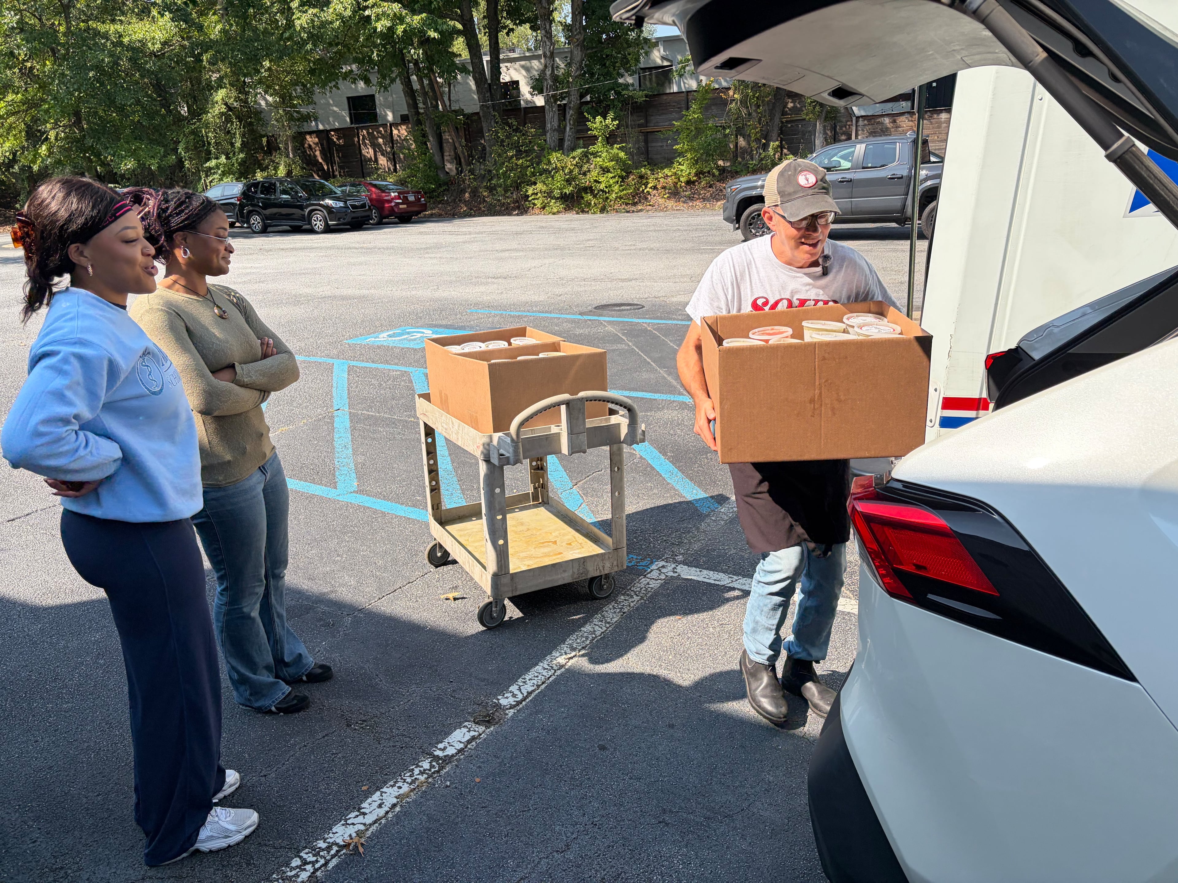 Keith Yaeger loads soup into the car of Leah Mohnkern (left) as Alisha Nkwonta stands by. The second-year Morehouse School of Medicine students reached out to Souper Jenny and its Zadie Project charity after learning their classmates were struggling to afford food. (Jason Armesto/AJC)