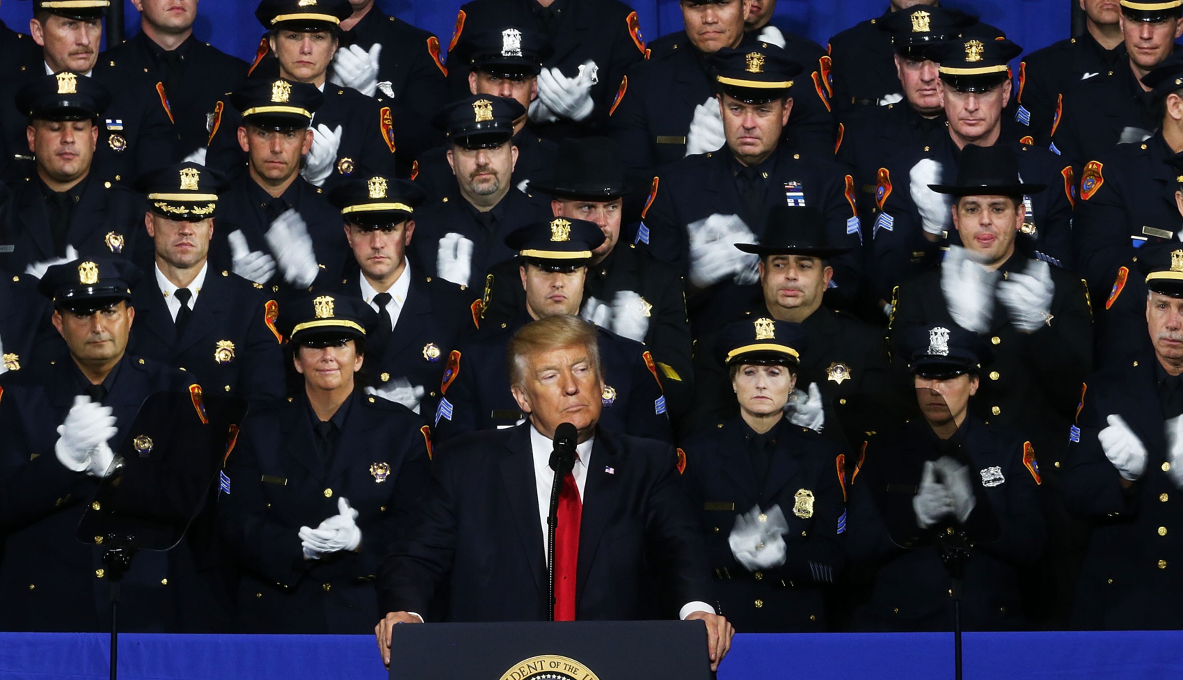 BRENTWOOD, NY - JULY 28: President Donald Trump speaks at Suffolk Community College on July 28, 2017 in Brentwood, New York. Trump, speaking close to where the violent street gang MS-13 has committed a number of murders, urged Congress to dedicate more funding to border enforcement and faster deportations. Trump spoke to an audience that included to law enforcement officers and the family members of crime victims. (Photo by Spencer Platt/Getty Images)