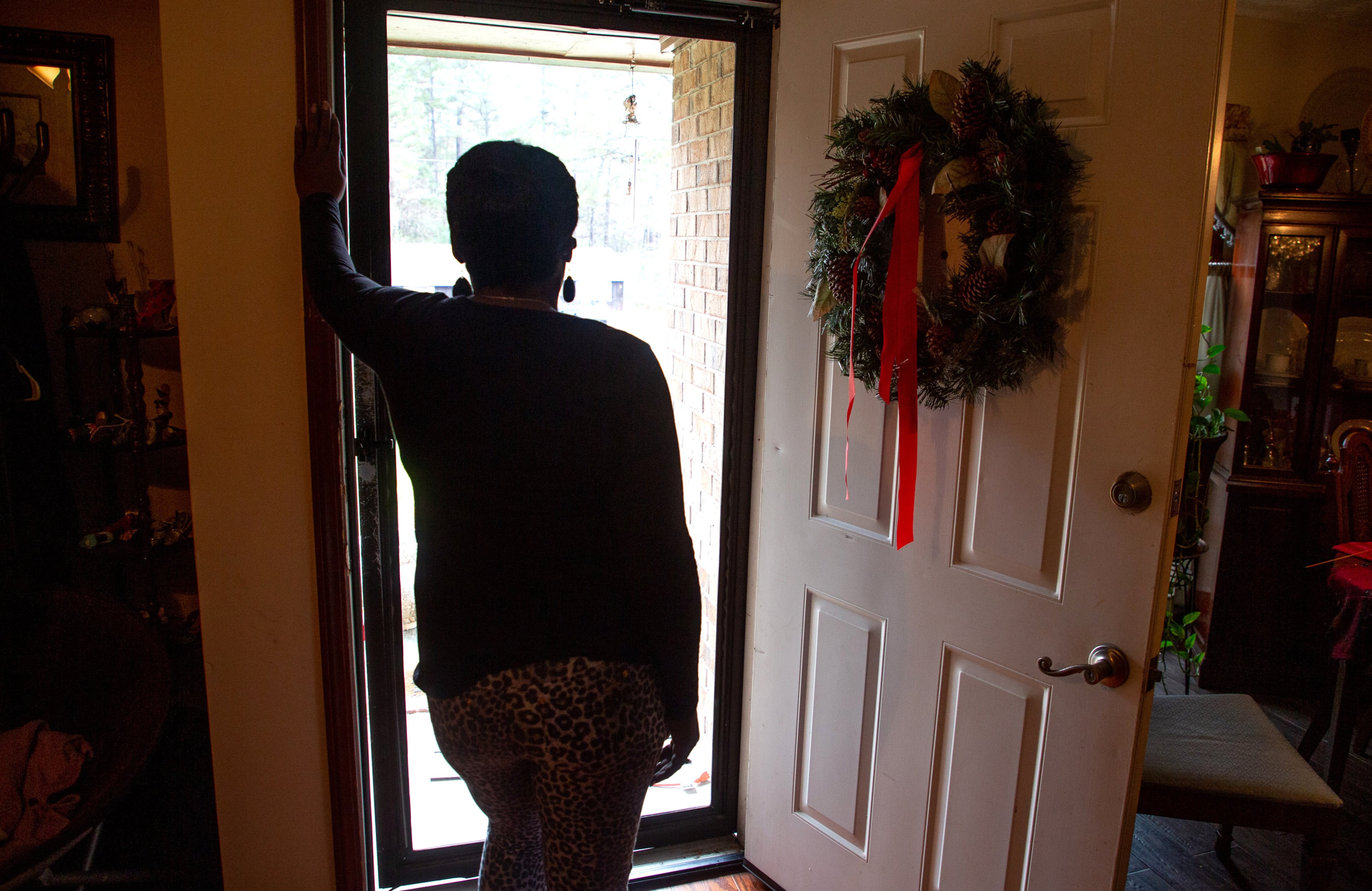 A client of the federal Housing Opportunities for Persons with AIDS program looks out the front door of the Ellenwood house where she was staying on Sunday, December 23, 2021. She is homeless after her case fell through the cracks of the city of Atlanta-run program. STEVE SCHAEFER FOR THE ATLANTA JOURNAL-CONSTITUTION
