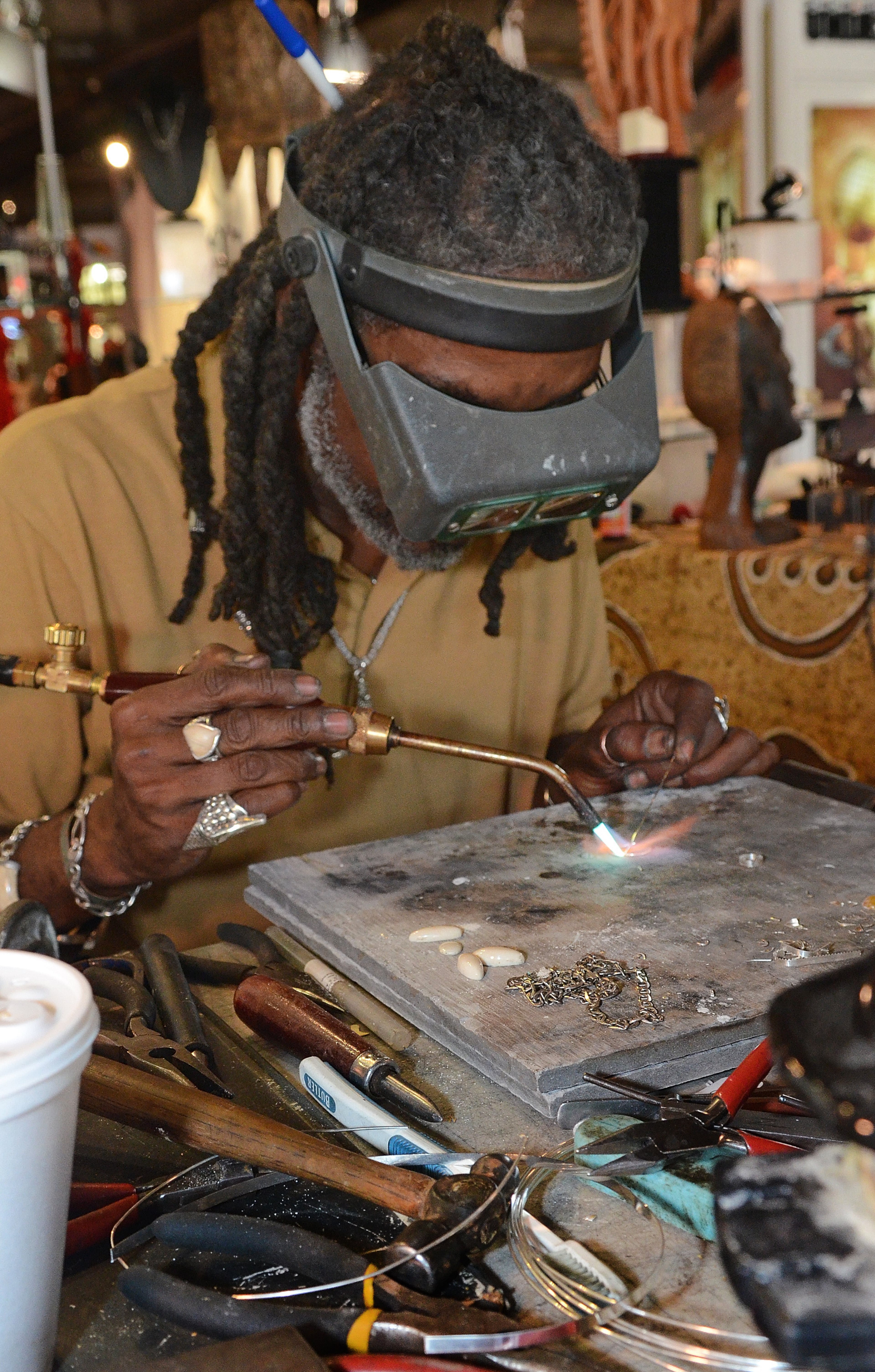 Razzau Wajid from Washington, D.C. solders silver earrings at the Timbuktu Art Colony display at the19th Annual Heritage Arts and Soul Festival at Underground Atlanta. The event features the work of over 30 artist, featuring fine art and wearable art, plus an emerging artist pavilion and fashion show. (CHRIS HUNT/SPECIAL)