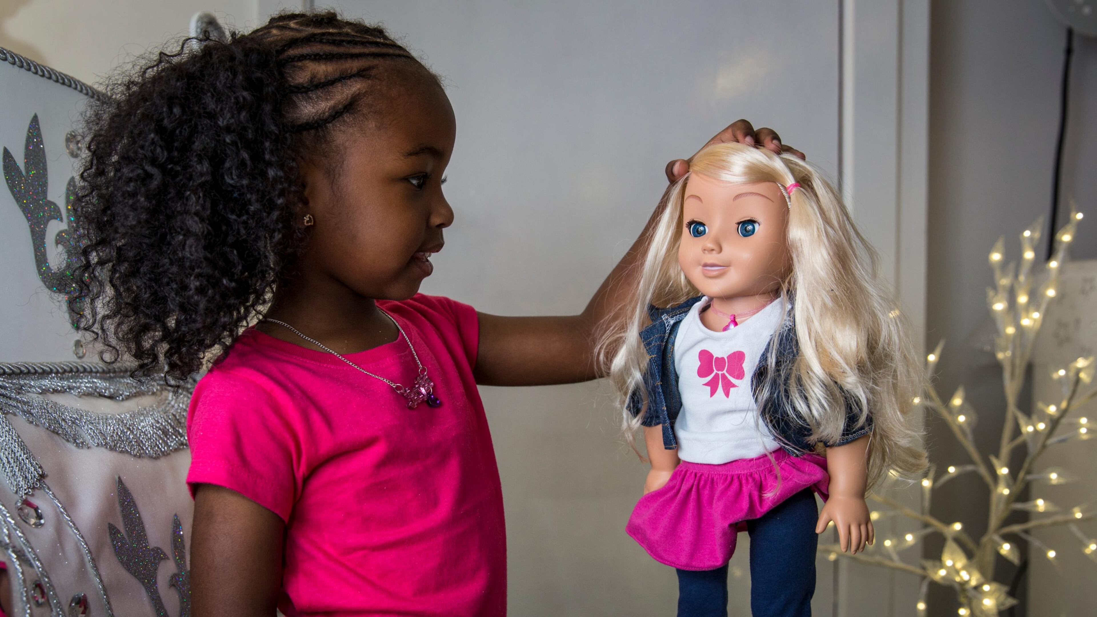 A little girl plays with a 'My Friend Cayla' doll at a store in London, England. The doll, which uses Bluetooth technology to connect to Android and iOS devices, is on a warning list for potential toy hacking threats.