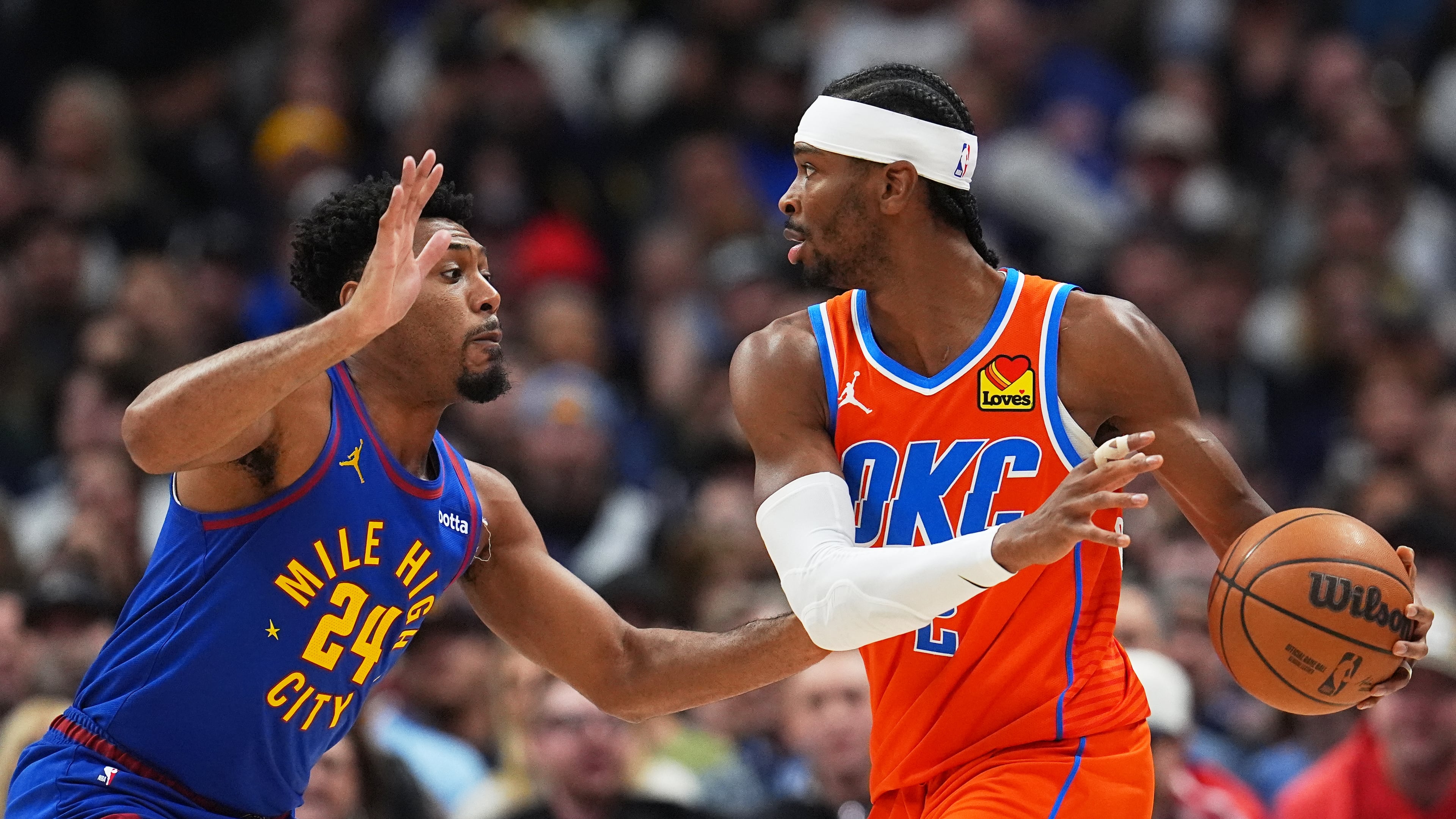 Oklahoma City Thunder guard Shai Gilgeous-Alexander, right, looks to pass the ball as Denver Nuggets guard Jalen Pickett defends in the first half of an NBA basketball game Sunday, Feb. 1, 2026, in Denver. (AP Photo/David Zalubowski)