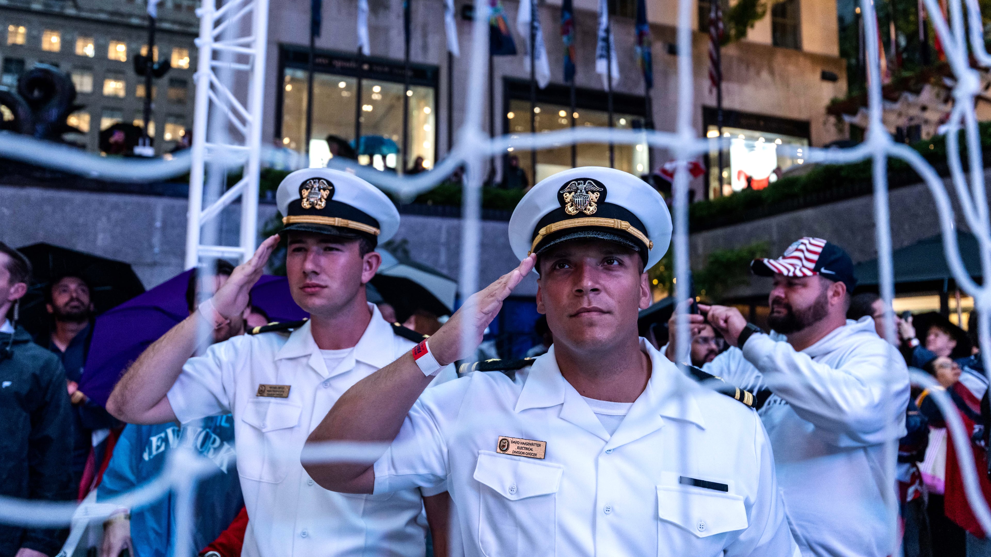 United States Navy personnel salute during the national anthem at a watch party in a fan village in New York's Rockefeller Center for a World Cup round of 16 soccer match between the United States and Belgium, Monday, July 6, 2026 in New York. (AP Photo/Adam Gray)
