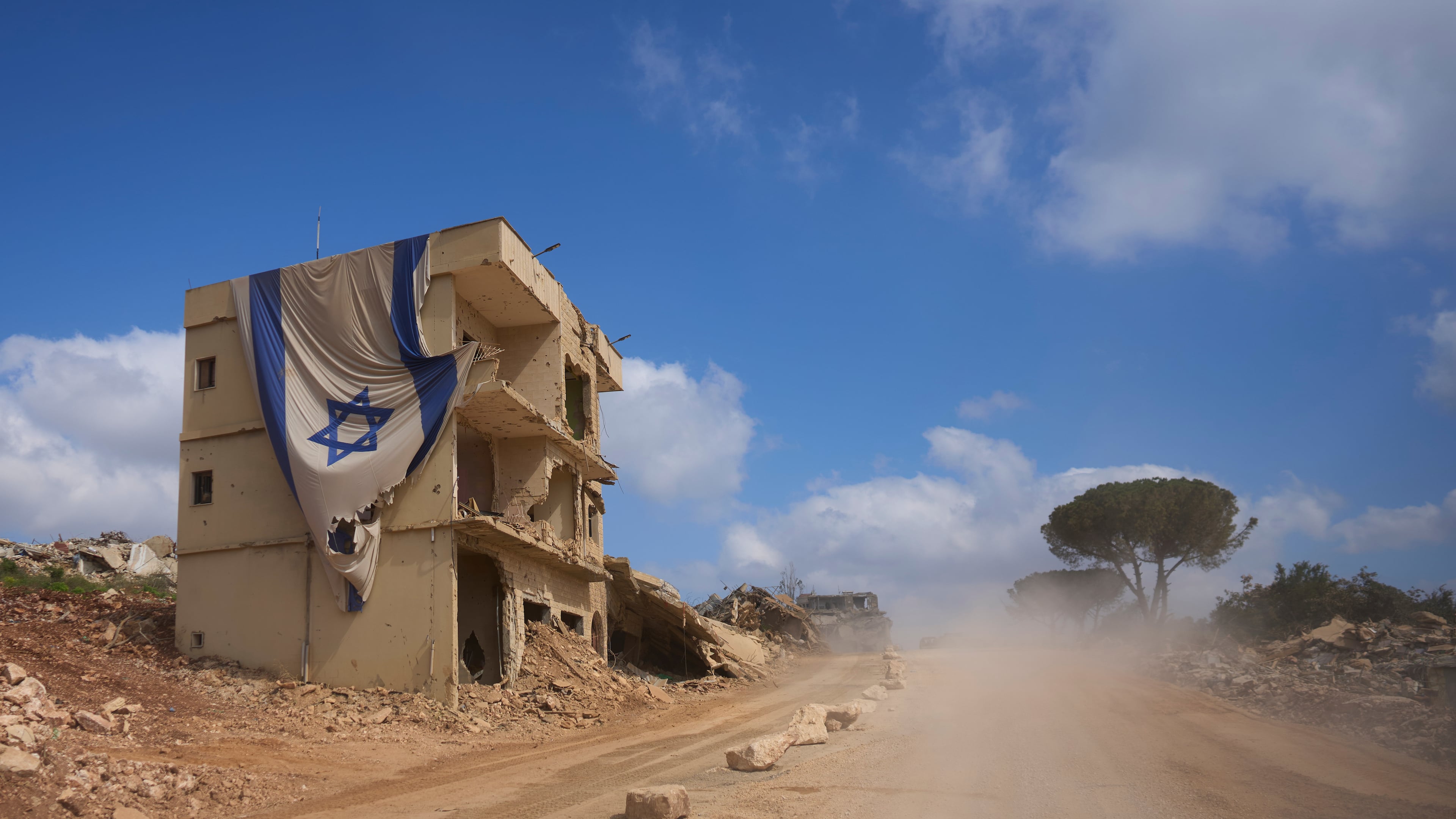 An Israeli flag hangs from a building in an area occupied by Israeli troops in southern Lebanon, Thursday, July 9, 2026. The Israeli military invited reporters on a tour of the strategic mountain topped by the Crusader-built Beaufort Castle months after launching a ground invasion that captured dozens of Lebanese villages and towns in southern Lebanon. (AP Photo/Ohad Zwigenberg)