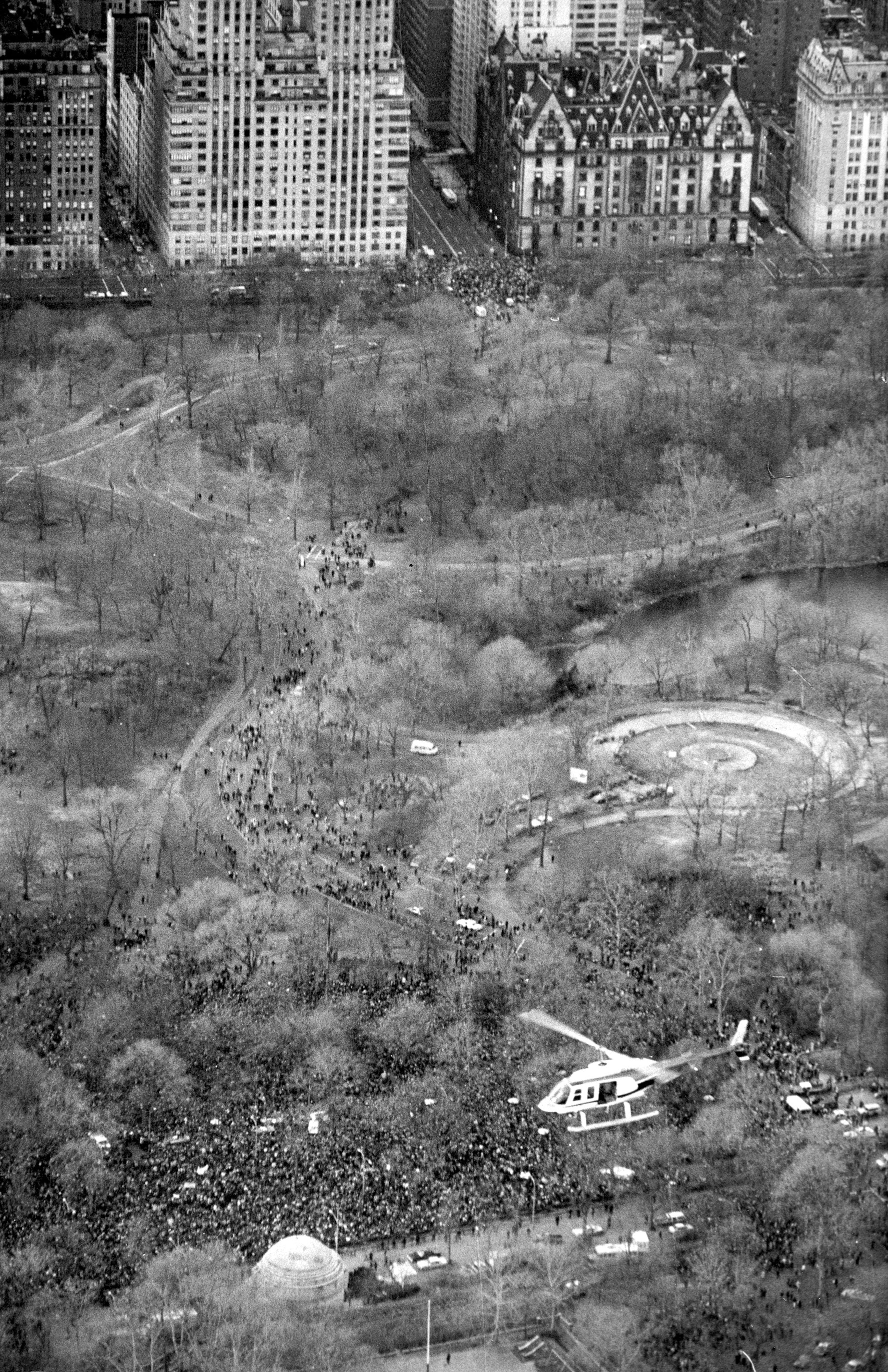 In this Dec. 14, 1980, file photo, a helicopter flies over Central Park in New York where an estimated crowd of between 50,000 to 100,000 people gathered to pay tribute to the late John Lennon. Thirty-five years ago in Dec. 8, Mark David Chapman shot and killed Lennon, a former Beatles member. (AP Photo/Dave Pickoff, File)