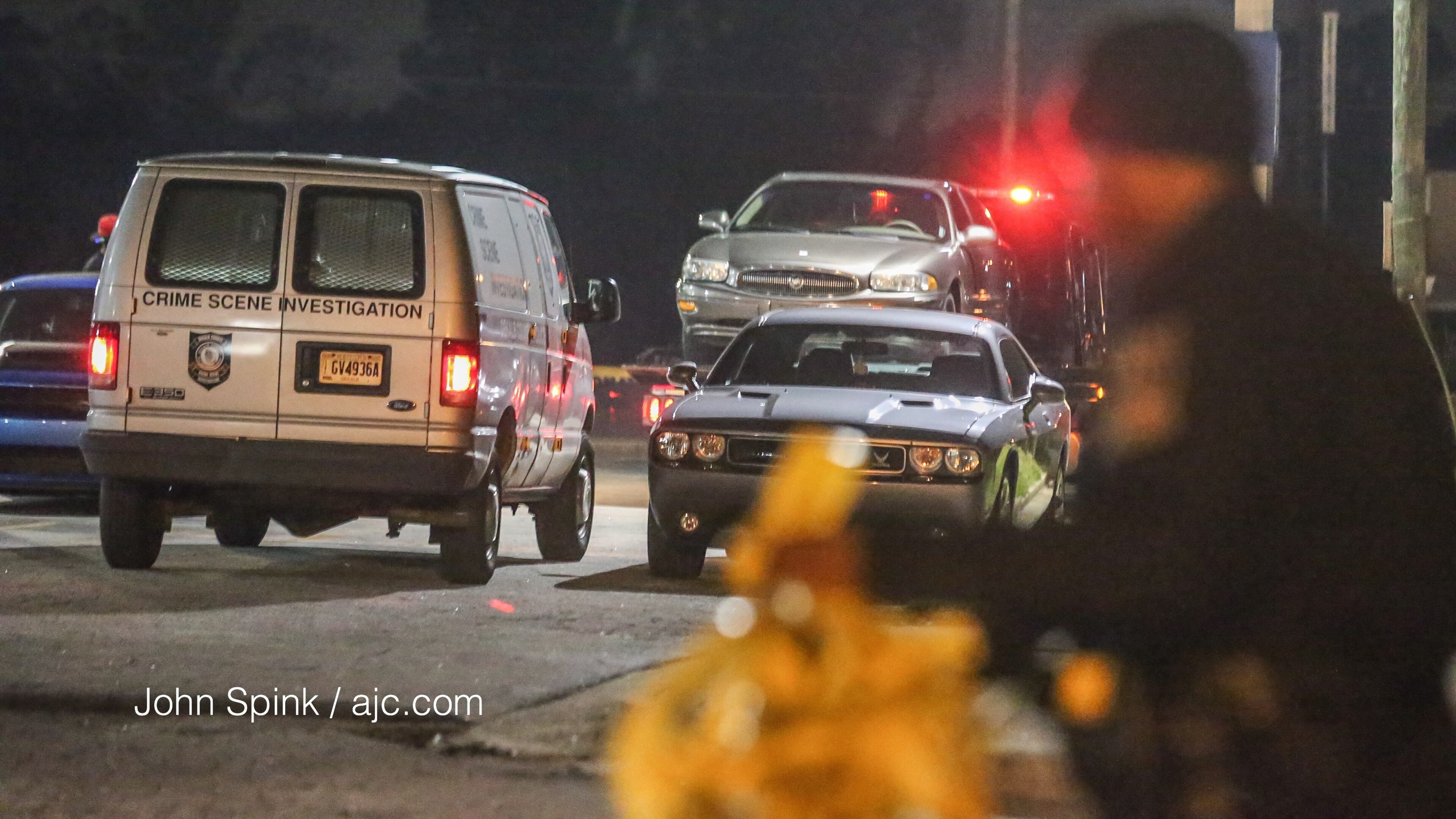 Police tow a car left at the Gulf American Inns after a shooting at the motel.