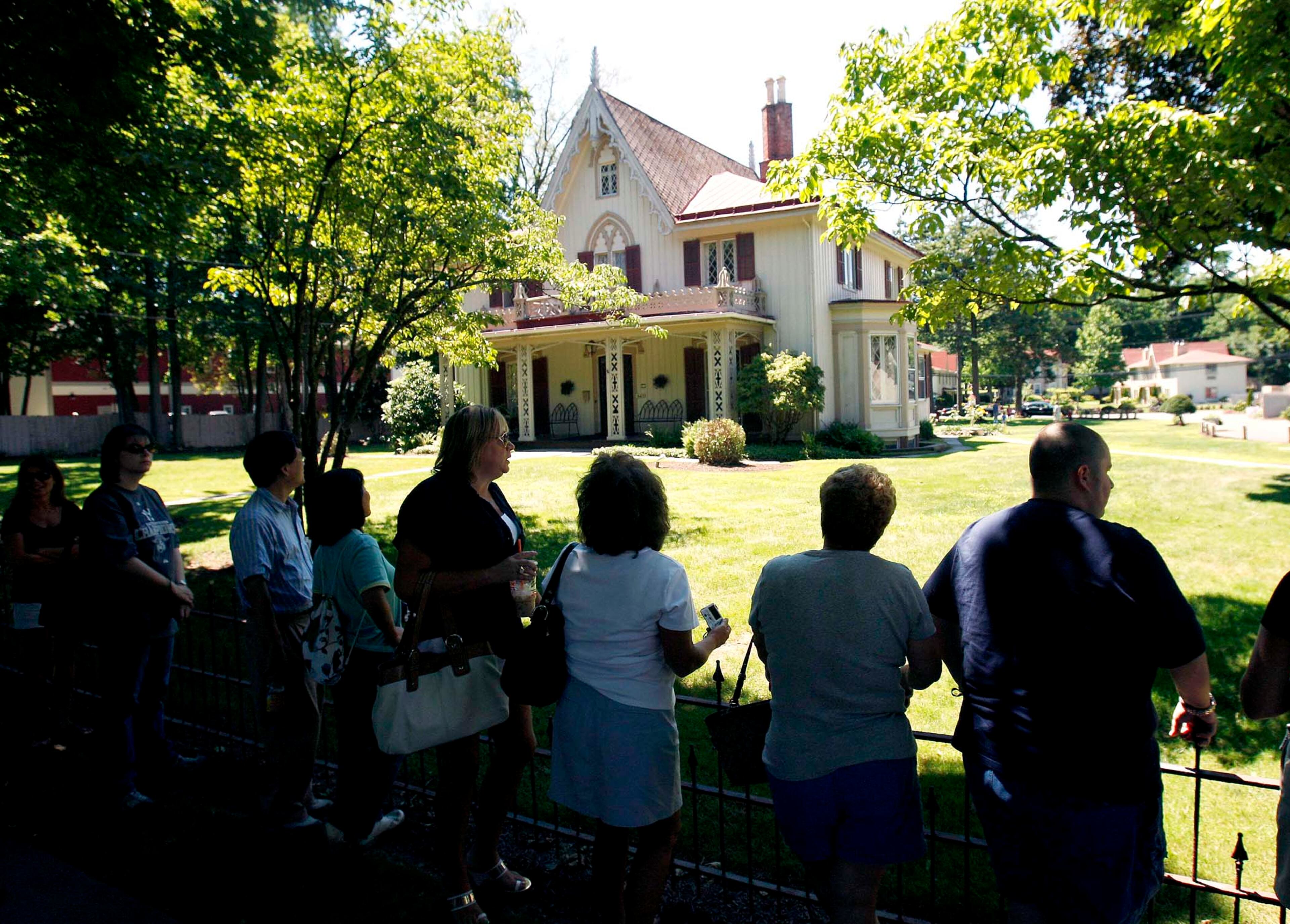 Members of the public stand outside the Delamater Inn waiting for invited guests to arrive for the wedding between Chelsea Clinton and fiance Marc Mezvinsky, in Rhinebeck, N.Y., on Saturday, July 31, 2010. (Mike Groll/Associated Press)