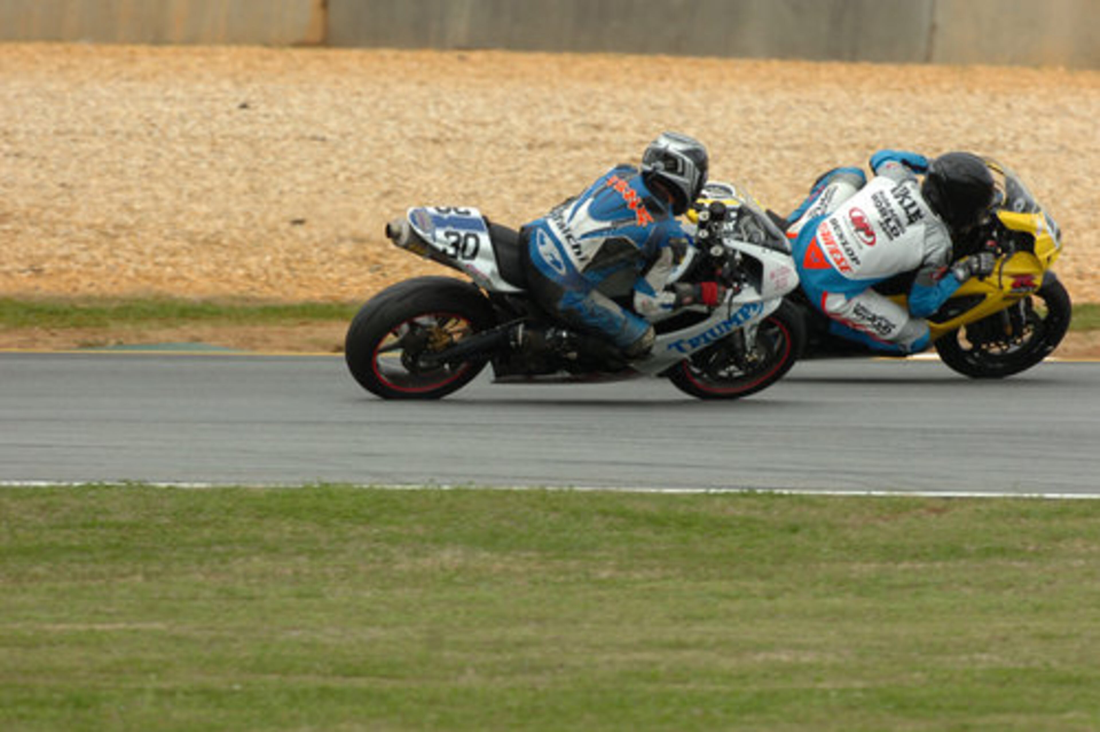 Bobby Fong (30) and Russ Wikle (right) jockey for position coming out of turn 10.