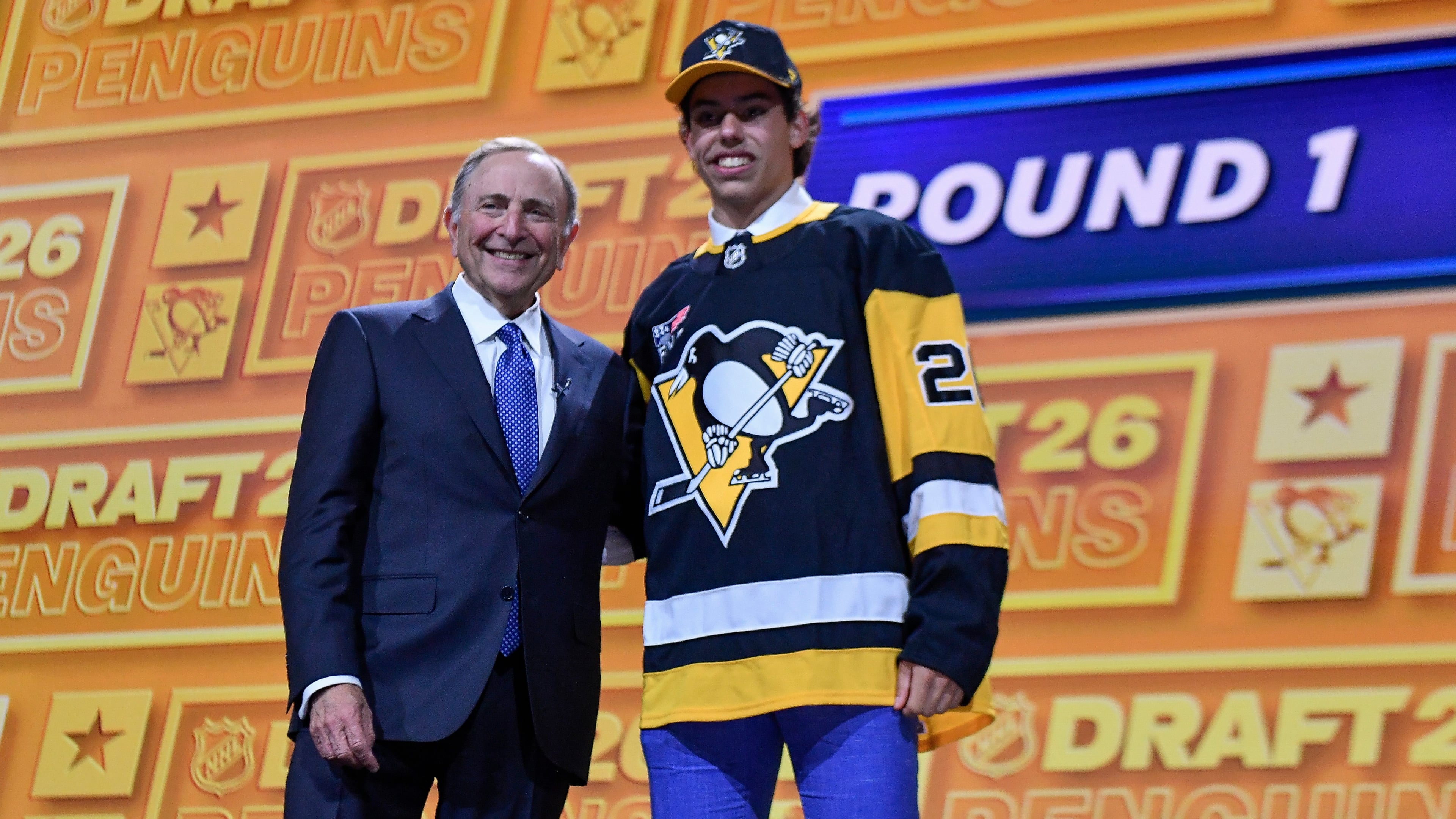 Liam Ruck, right, stands with NHL Commissioner Gary Bettman after being drafted by the Pittsburgh Penguins during the NHL hockey draft Friday, June 26, 2026, in Buffalo, N.Y. (AP Photo/Adrian Kraus)