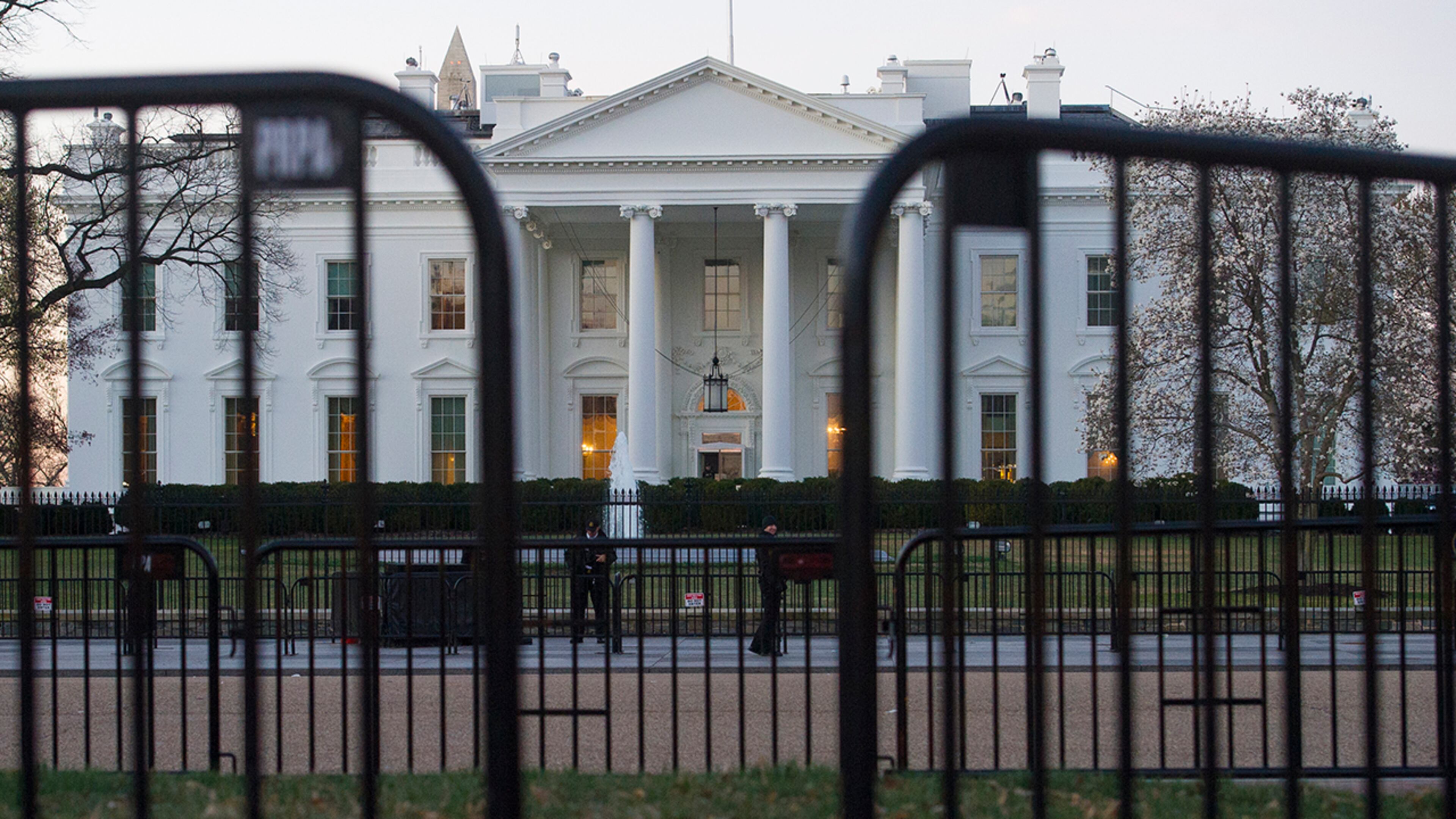 In this March 24, 2019 photo, The White House is seen behind security barriers in Washington. A White House official turned whistleblower says dozens of people in President Donald Trump's administration were granted access to classified information despite "disqualifying issues" in their backgrounds including concerns about foreign influence, drug use and criminal conduct. (AP Photo/Cliff Owen)