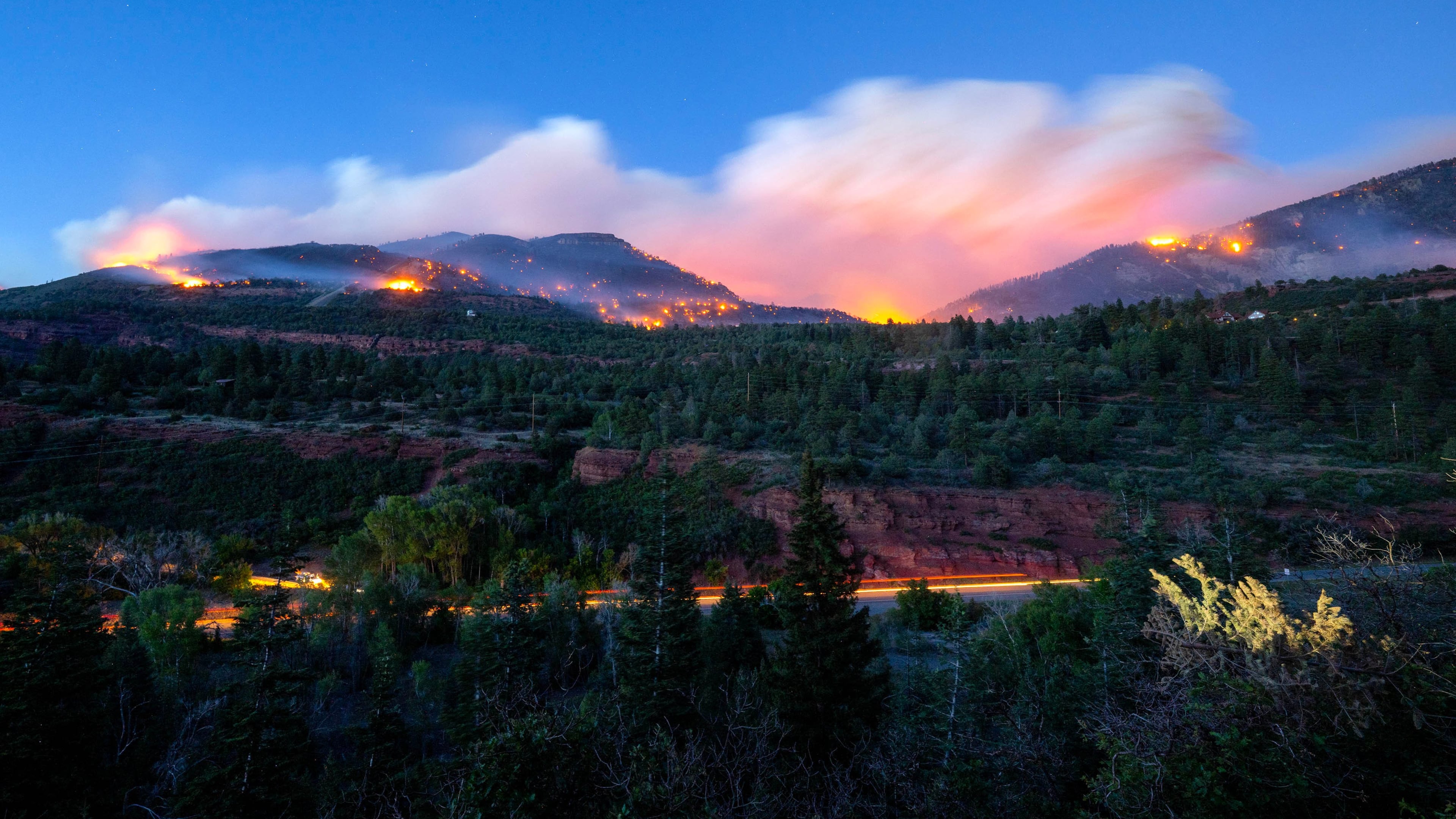 Firefighters drive along Highway 550 as they try to access the Gold Mountain Fire on the town line of Ouray and Ridgeway, Colo., on Sunday, June 28, 2026. (Michael Seamans/The Gazette via AP)