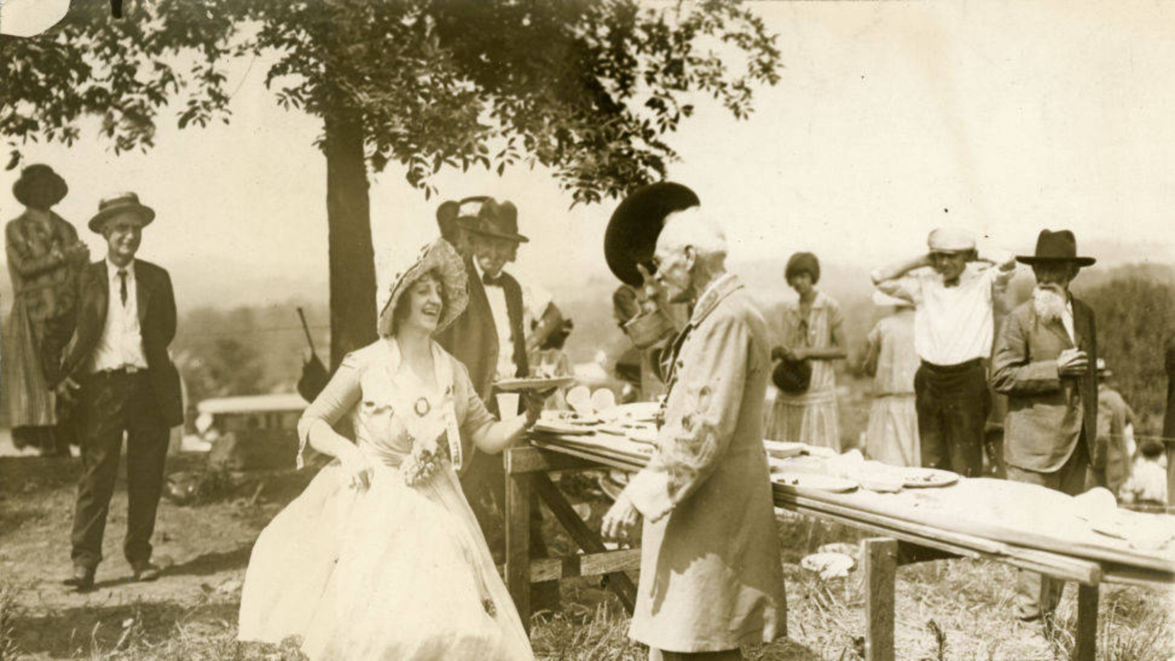 From the original caption, published in 1926: "Major J.L. McCollum, veteran of the Civil War, doffs his hat to Mrs. Warren Vinson, dressed as a girl of the old south, at exercises held by veterans of the Blue and the Gray at Marietta, Ga., June 26, in commemoration of the 62nd anniversary of the Battle of Kennesaw Mountain."