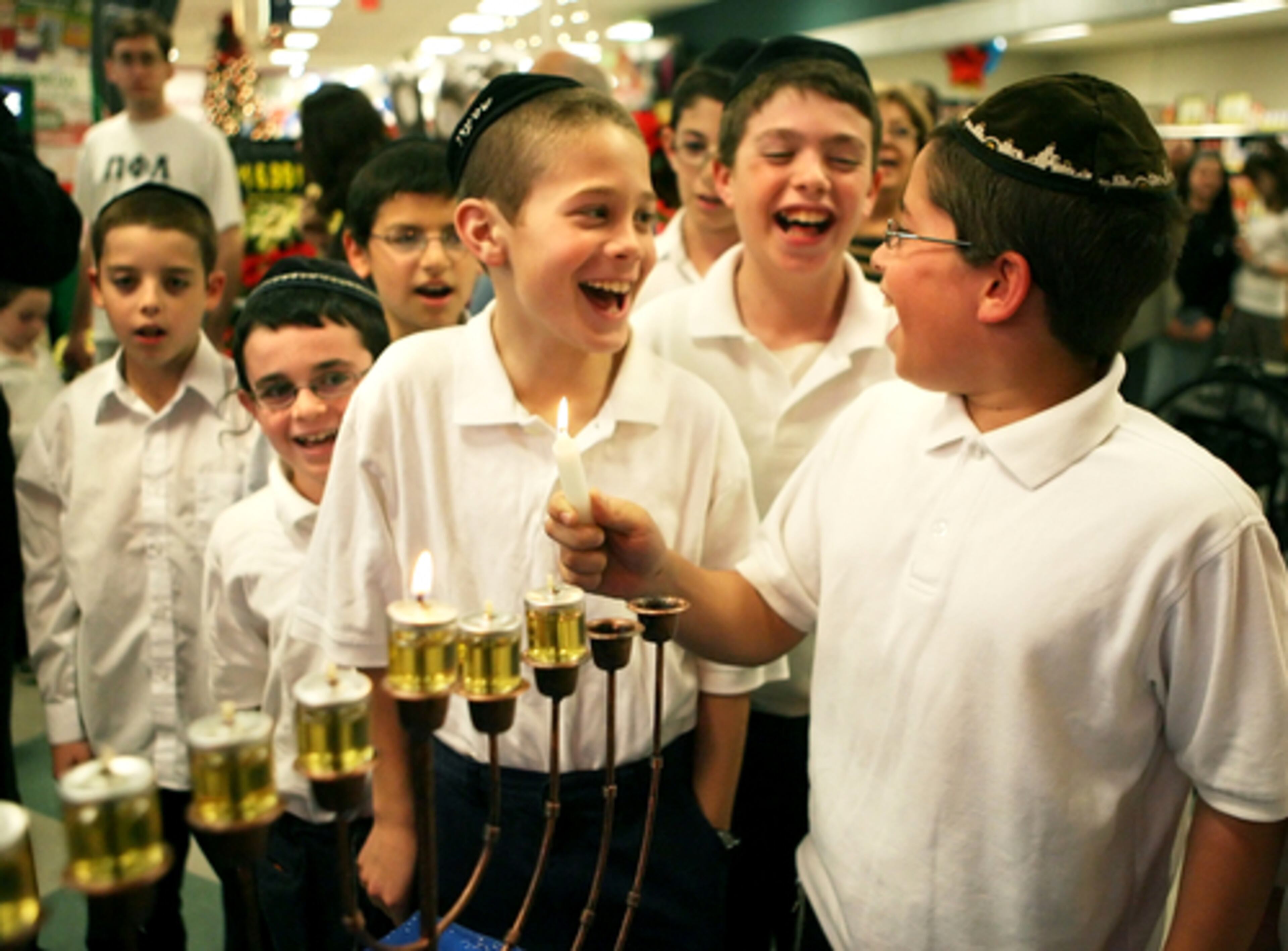 Yechezkel Estreicher, 11, right, and Shimon Stroll, 9, front center, of the Torah Day School kids' choir take part in the Menorah lighting and Hanukkah celebration at the Toco Hills Kroger. Hanukkah is the eight-day Jewish celebration commemorating the rededication of the second Temple of Jerusalem in the 2nd century BCE.
