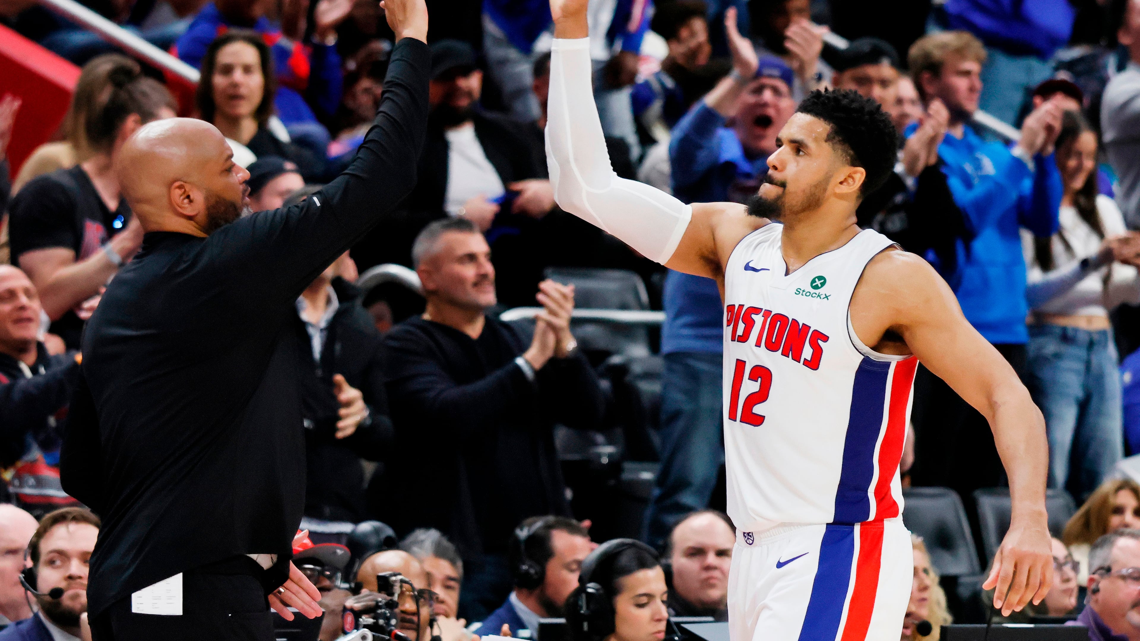 Detroit Pistons forward Tobias Harris (12) celebrates with head coach J.B. Bickerstaff, left, as he leaves late in the fourth quarter of a win over the Orlando Magic in Game 7 of a first-round NBA basketball playoffs series Tuesday, May 2, 2026, in Detroit. (AP Photo/Duane Burleson)